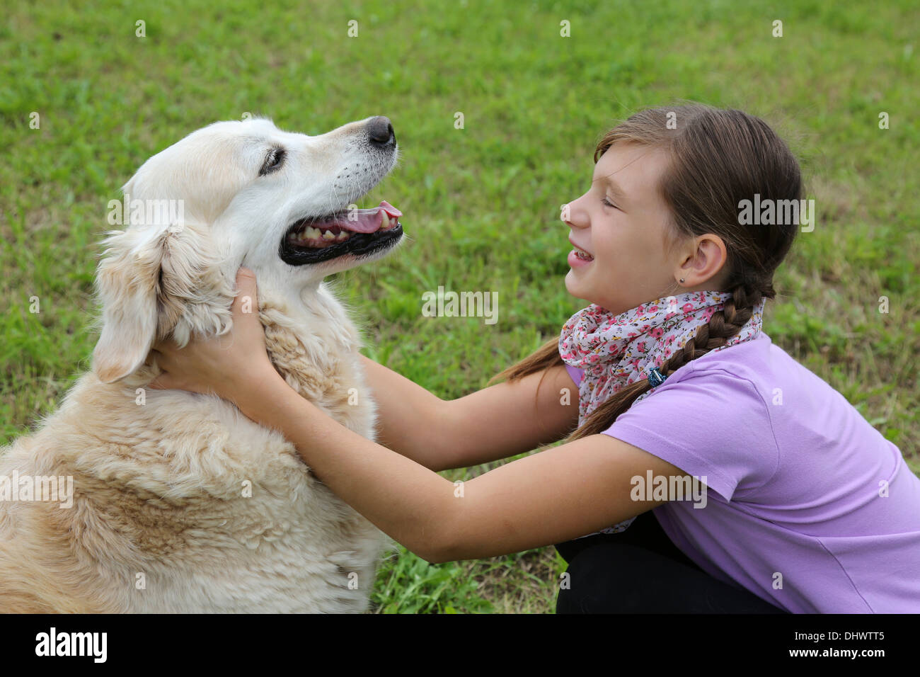 Little girl playing with a dog on a meadow Stock Photo - Alamy