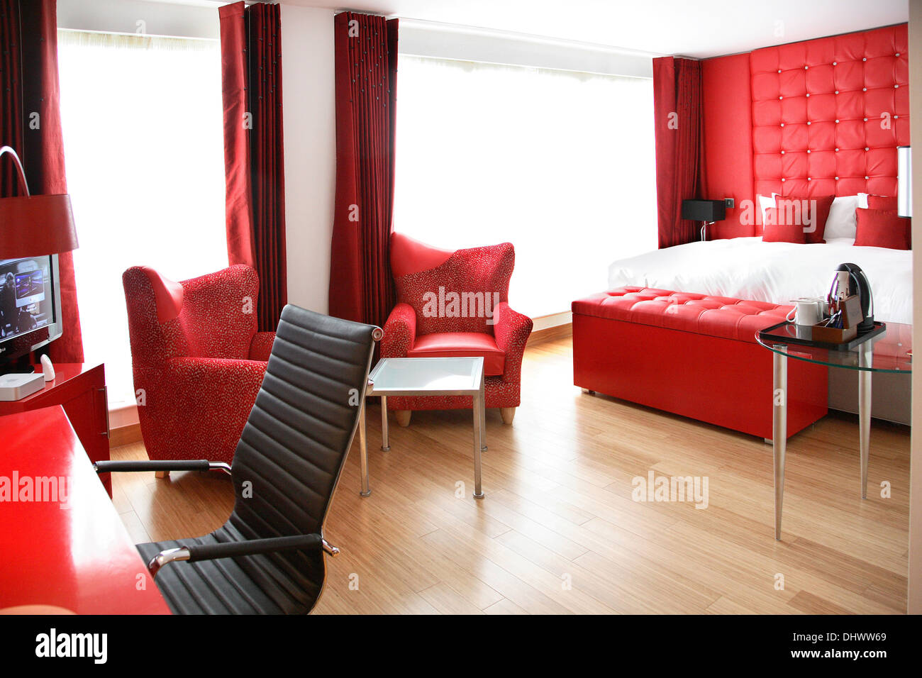 A modern hotel room featuring a distinctive bright red colour scheme Stock Photo