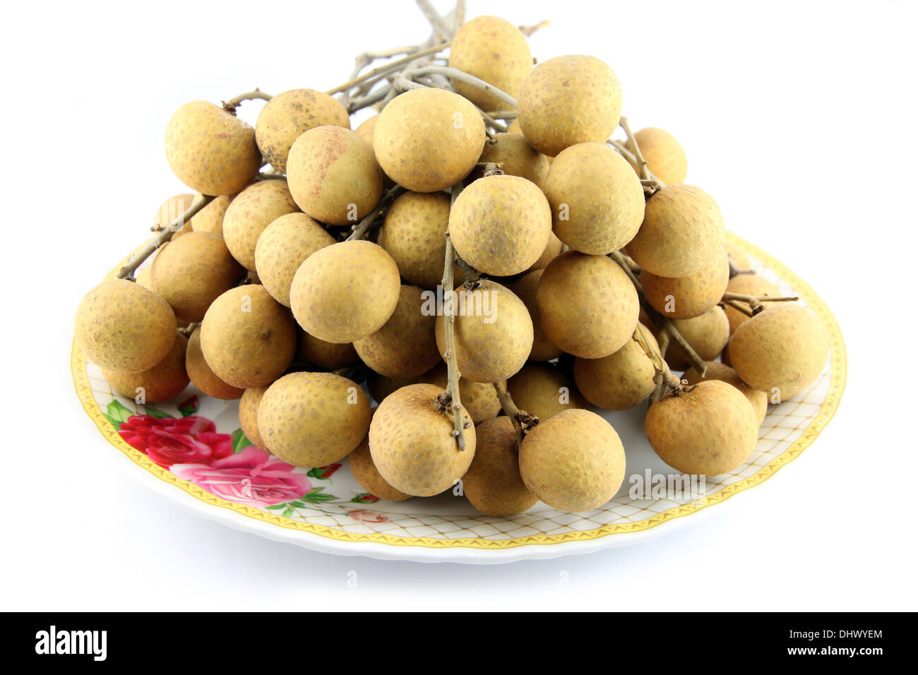 Fresh Longan tied together, placed in a dish on white background. Stock Photo