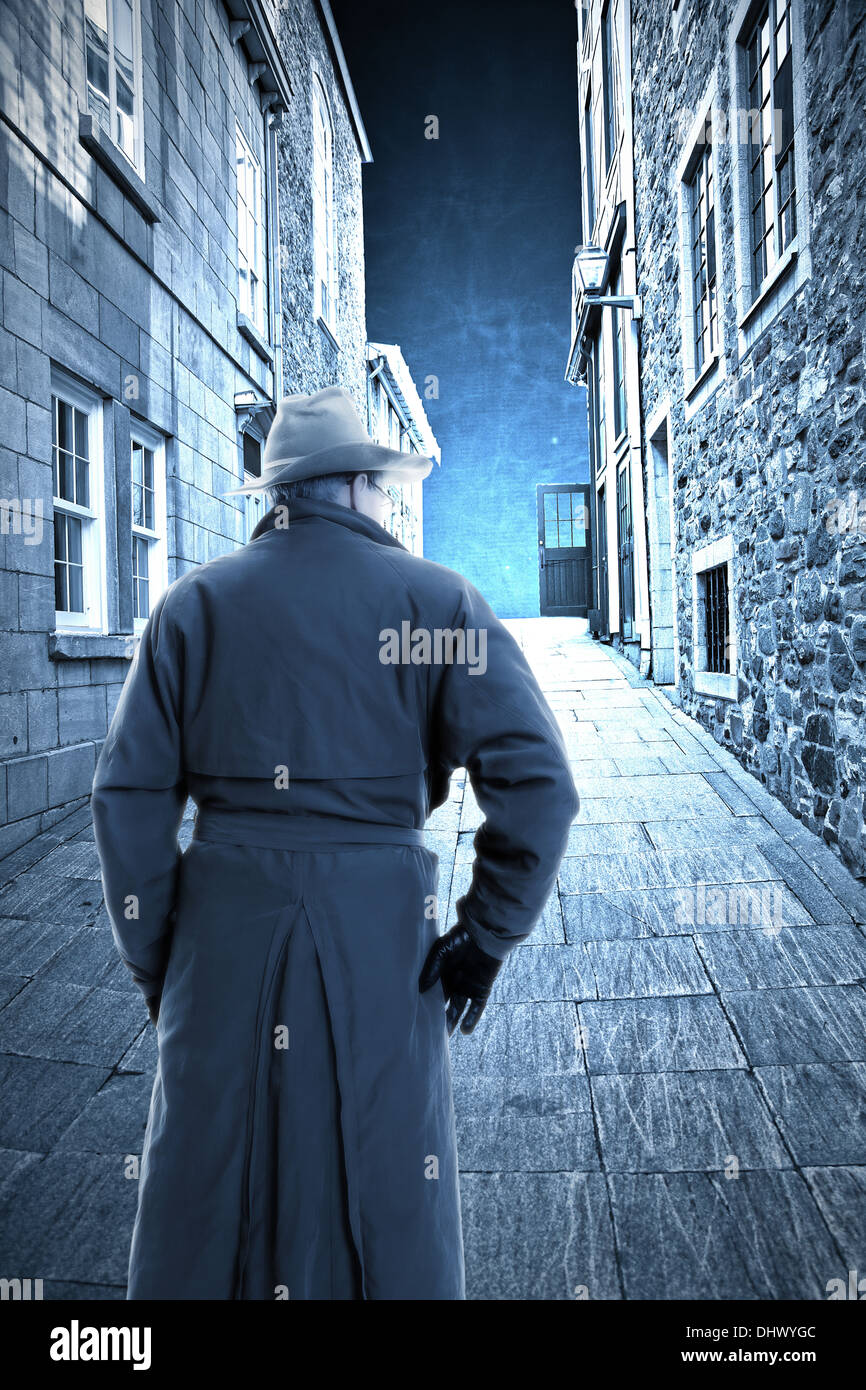 Man in hat and trench coat on old city street Stock Photo - Alamy