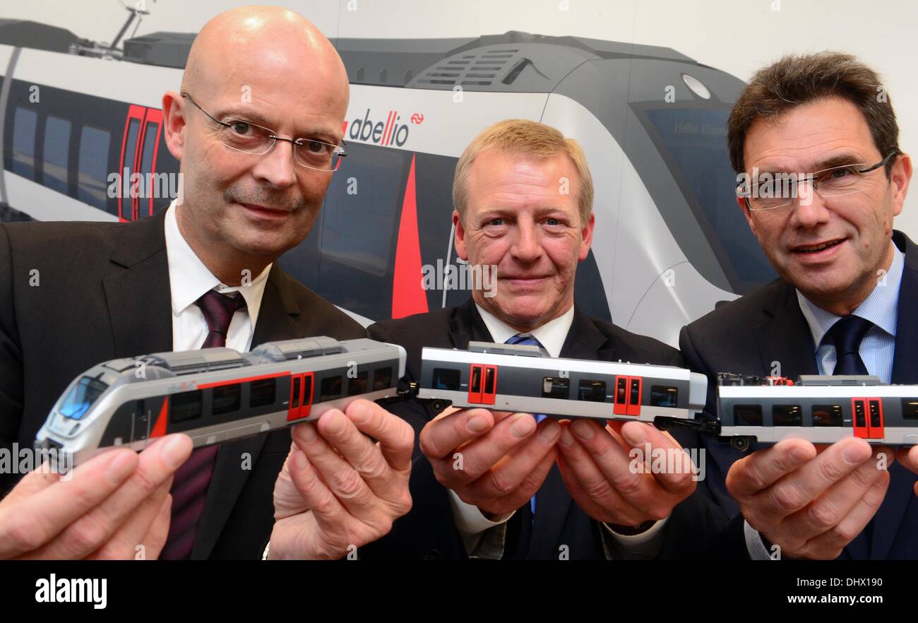 Mayor of Halle (Saale), Bernd Wiegand (L-R), CEO of the transport company Abellio Germany, Bernd Kemper, and Klaus Ruediger Malter of the local traffic service company Saxony-Anhalt hold a model of an Abellio train at a press conference in Halle (Saale), Germany, 15 November 2013. The transport company Abelio Rail Central Germany plans to locate in the Central German rail transport. Photo: Hendrik Schmidt/dpa Stock Photo