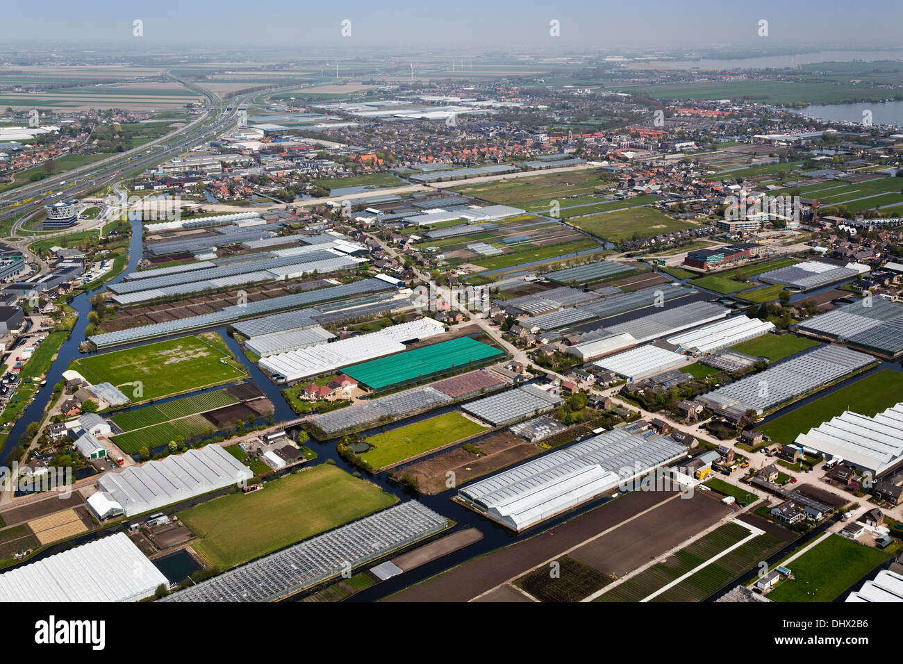 Netherlands, Roelofarendsveen, Highway A4 and industrial area, greenhouses. Aerial Stock Photo