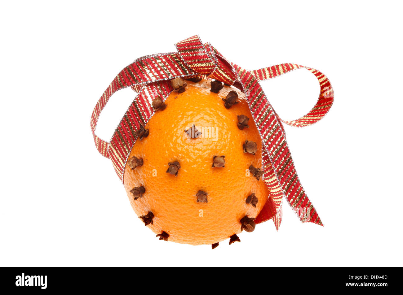 Orange decorated with cloves and a ribbon isolated against white Stock Photo