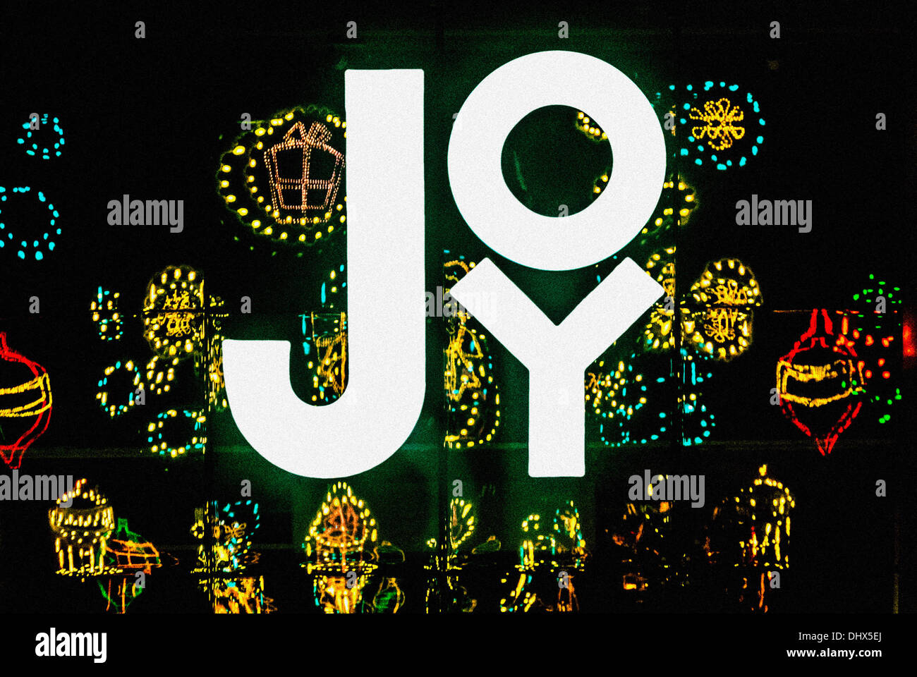 JOY shop sign with reflections of Christmas illuminated decorations Stock Photo
