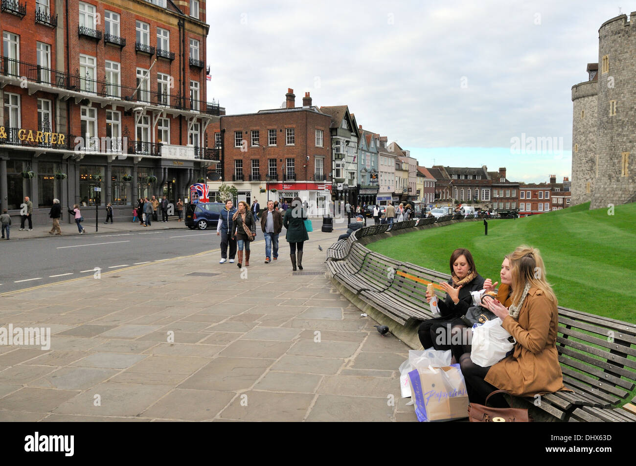 Women eating lunch on bench by Thames Street outside Windsor Castle, UK Stock Photo