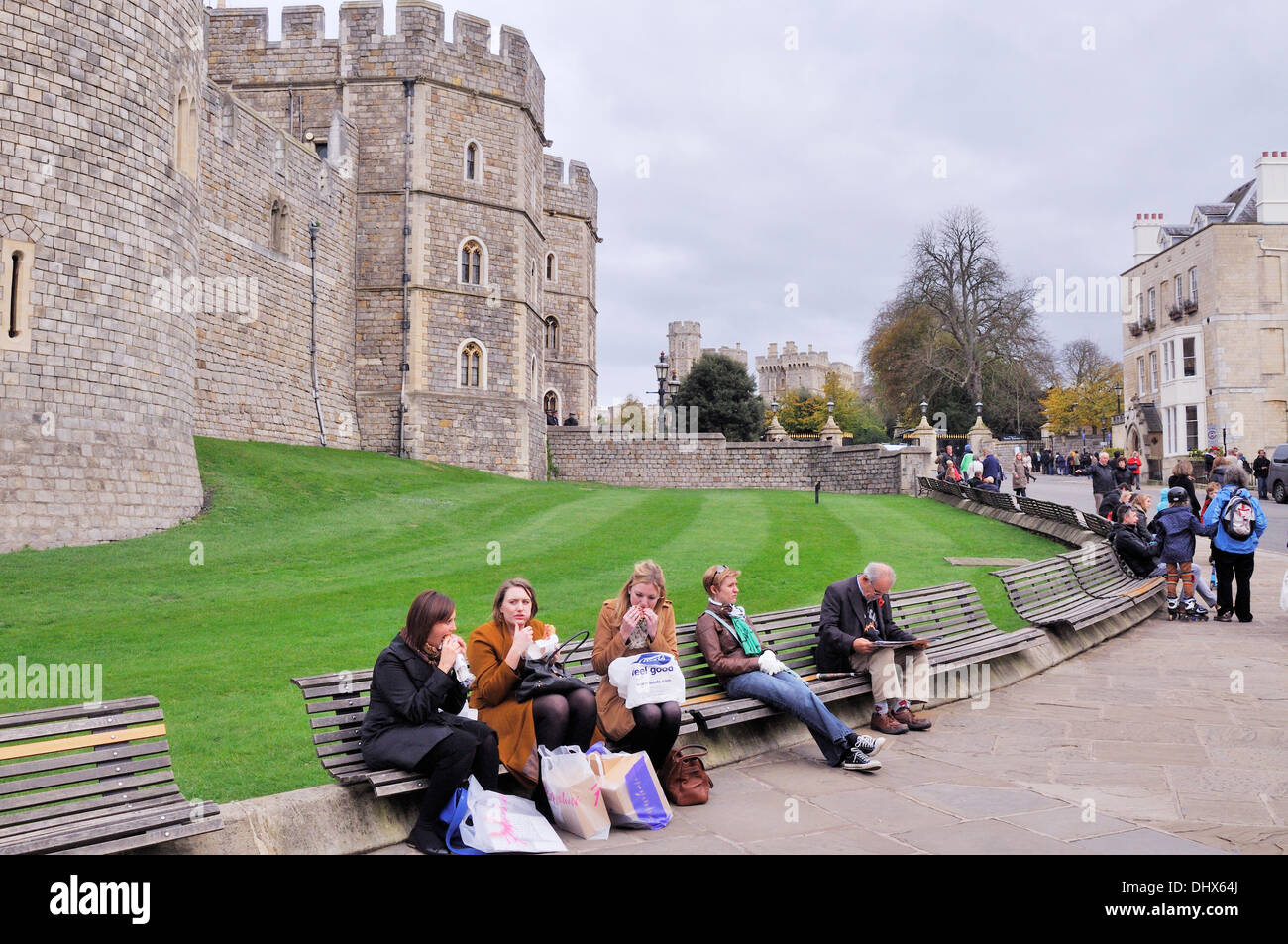 People on benches outside Windsor Castle, UK Stock Photo
