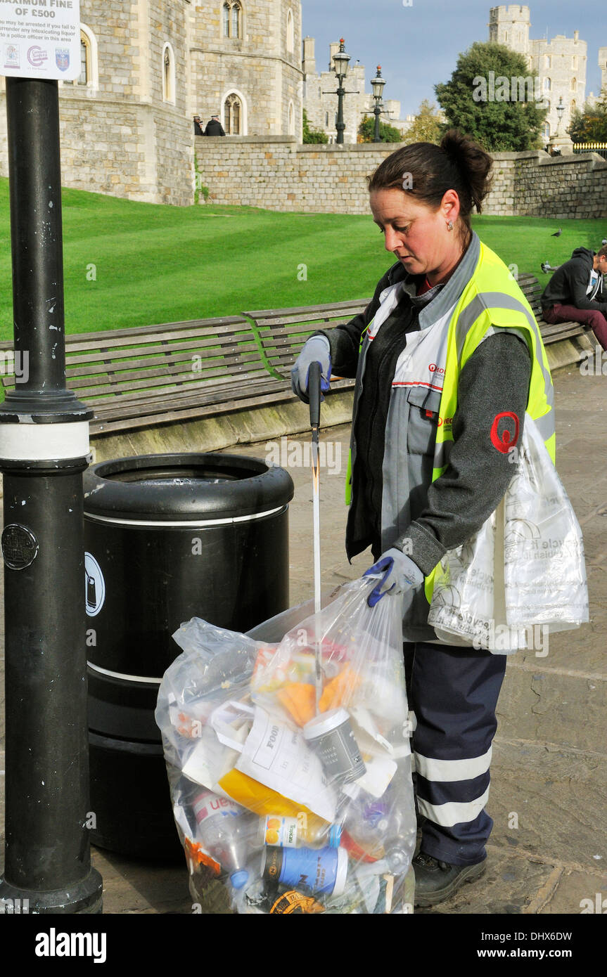 Woman picking up litter from street outside Windsor Castle Stock Photo