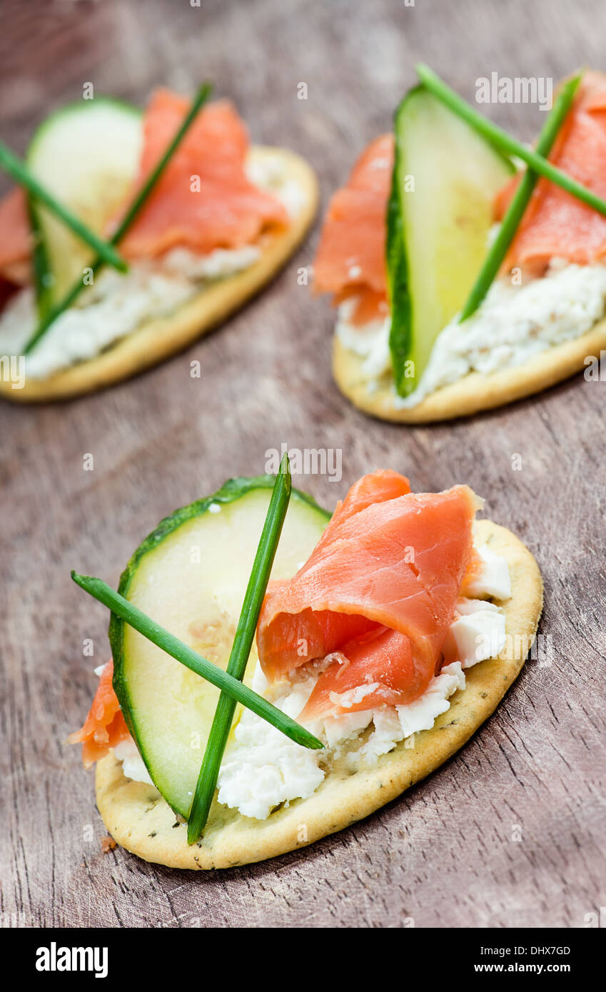 Canapes with smoked salmon, cucumber and cream cheese, selective focus
