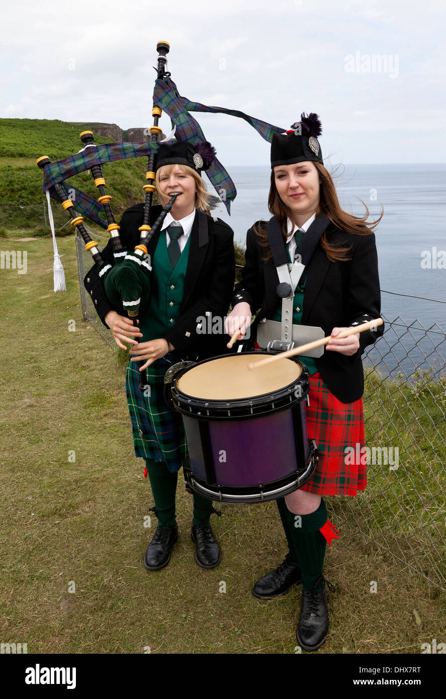 Two teenage girls playing the bagpipes and drum at the Kilt Rock, Isle of Skye, Scotland UK Stock Photo
