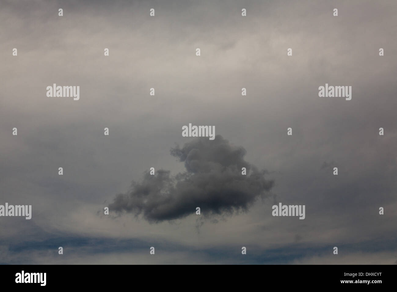 Gray Puffy Cloud Against Overcast Sky Stock Photo