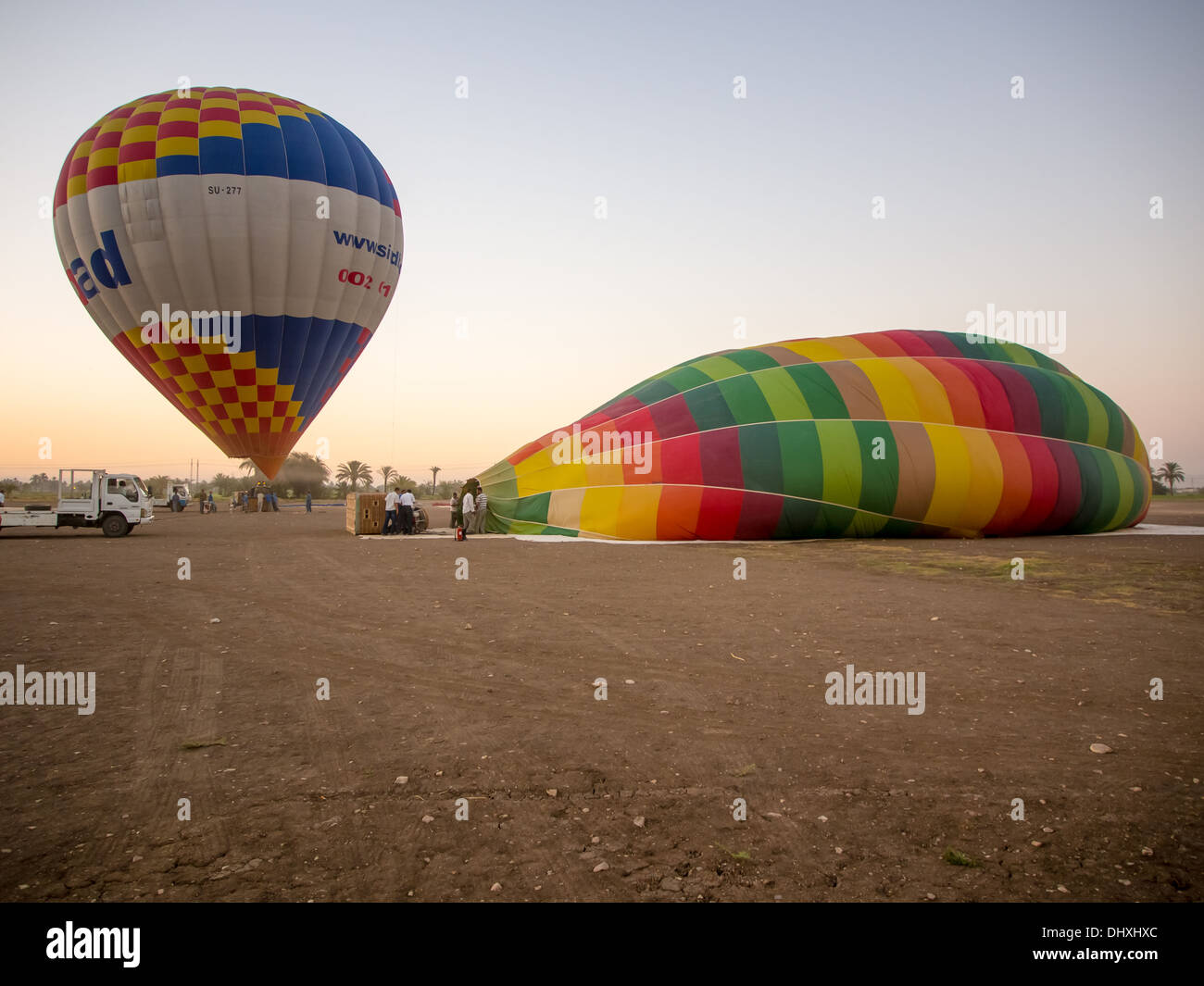 Hot air balloons are prepared for launch at dawn, on the West bank of the river Nile in Luxor, Egypt. Stock Photo
