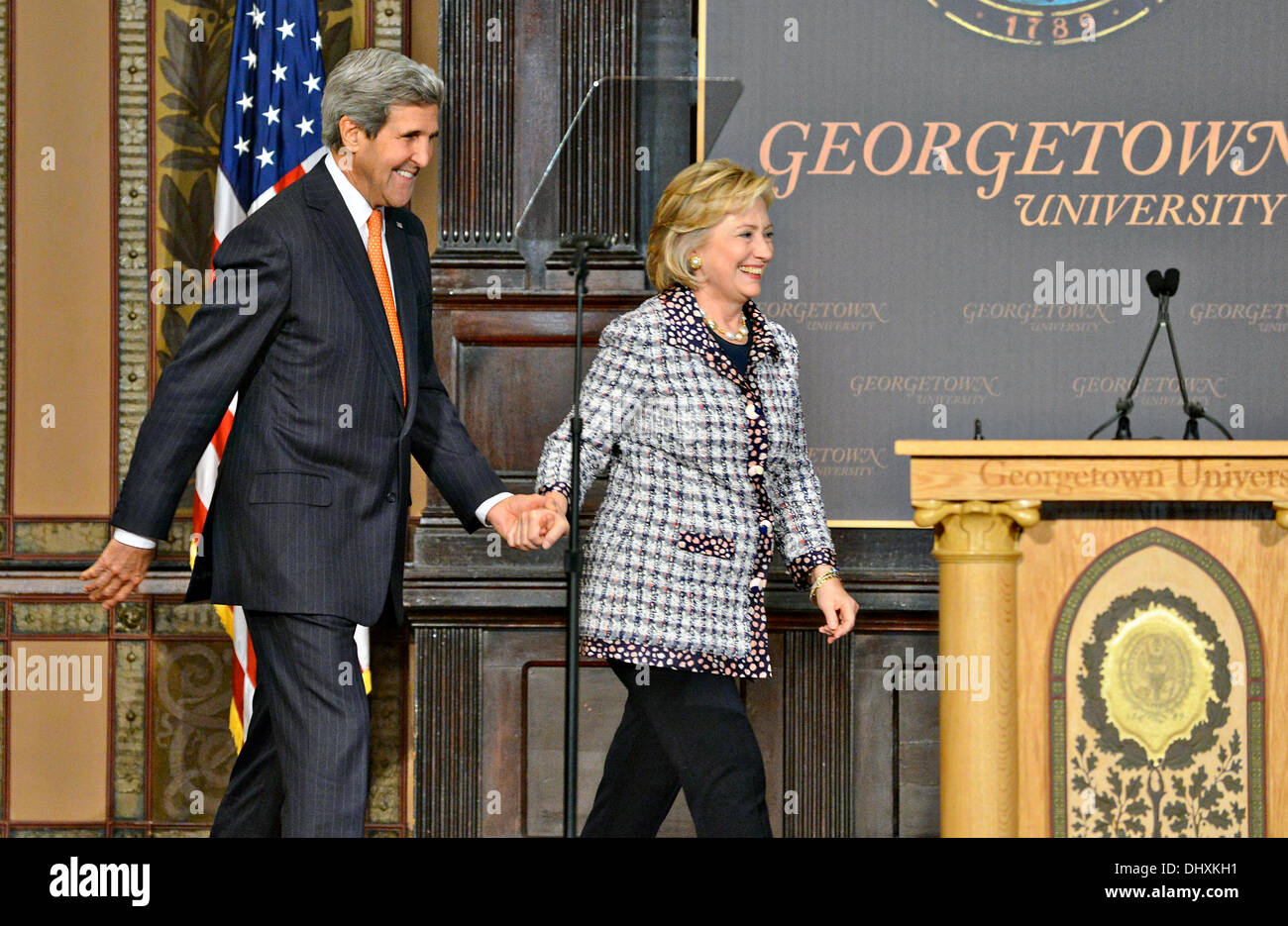 US Secretary of State John Kerry holds hands with Former Secretary of State Hillary Clinton as they walk on stage together at the Georgetown University Symposium Advancing Afghan Women: Promoting Peace and Progress in Afghanistan at Georgetown University November 15, 2013 in Washington, DC. Stock Photo
