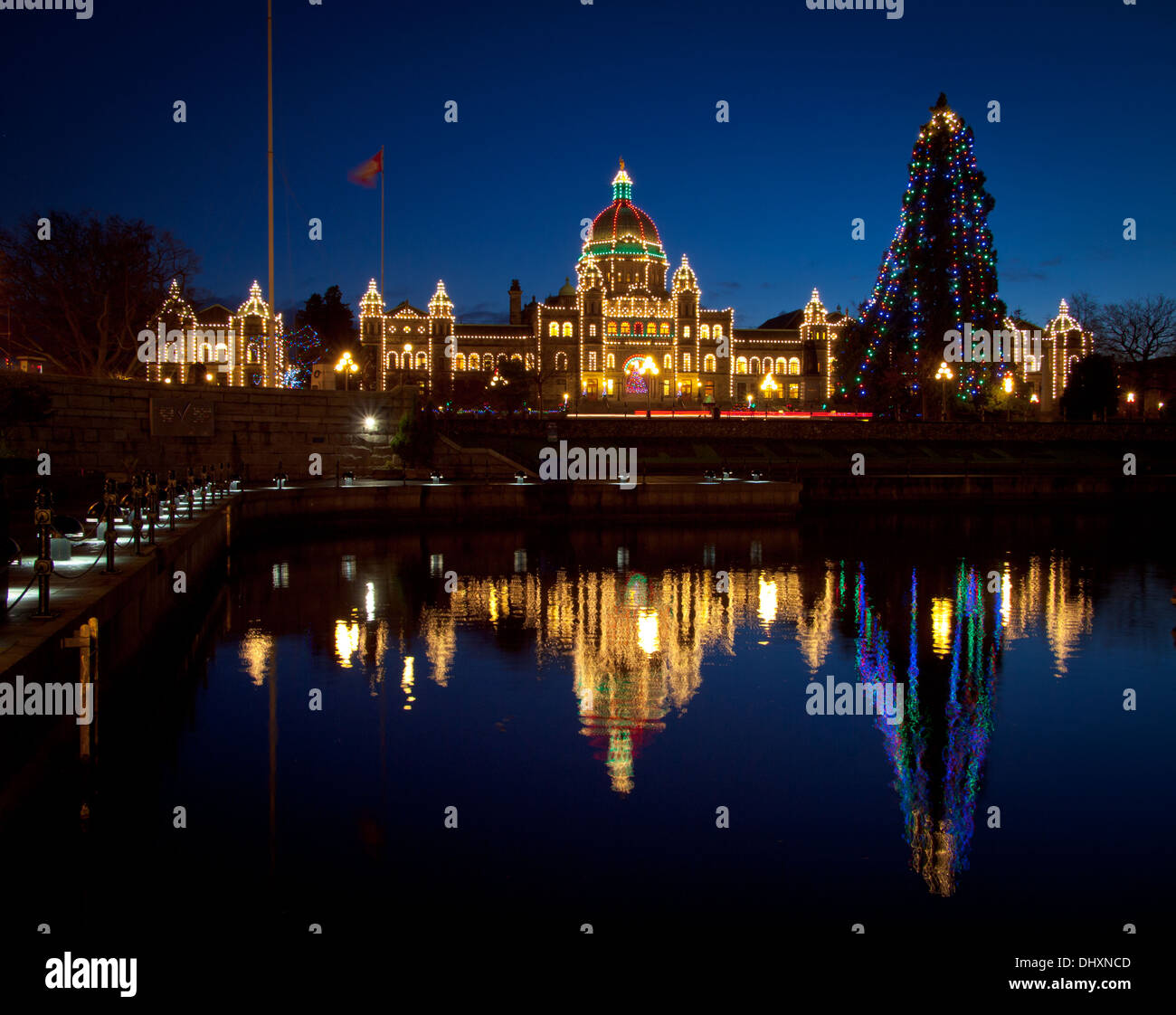A view of the British Columbia Parliament building, adorned in Christmas lights, and the Victoria Inner Harbour. Stock Photo