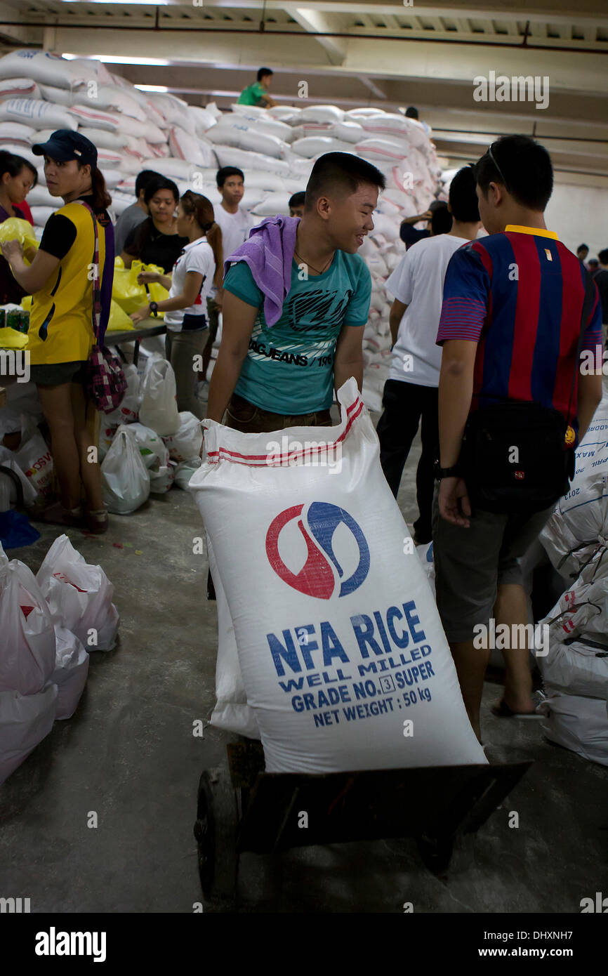 International Convention Centre,Cebu City 16/11/2013. A Cebu City initiative involving a number of Government Agencies in the aftermath of Typhoon Haiyan/Yolanda. A 24hr relief aid operation involves the receiving and re-packing of food items destined for the hardest hit areas. Volunteers are mainly students. Relief packs contain 6 kilos of rice,5 tins of sardines,5 tins of corned beef/beef loaf. Stock Photo