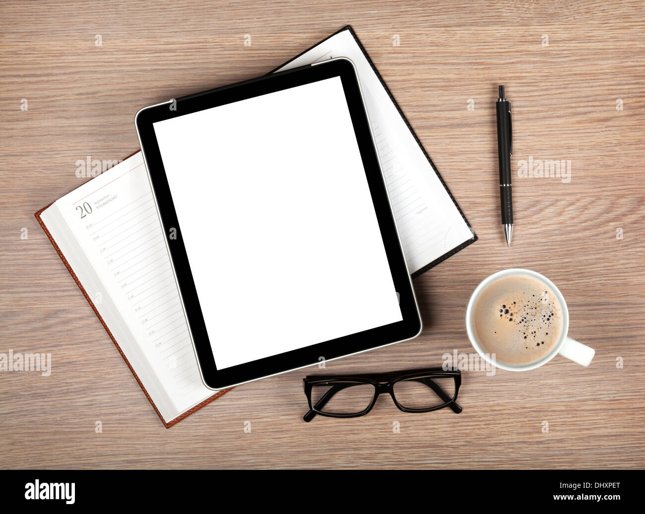 Tablet with blank white screen and coffee cup on office wooden table Stock Photo