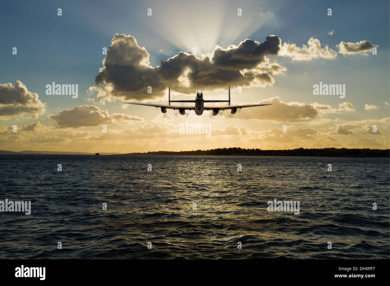 Avro Lancaster bomber in silhouette, heading into the sunset at low level over a coastal seascape. Stock Photo