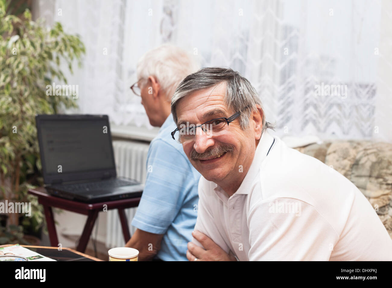 Two happy seniors learning to use a computer. Stock Photo