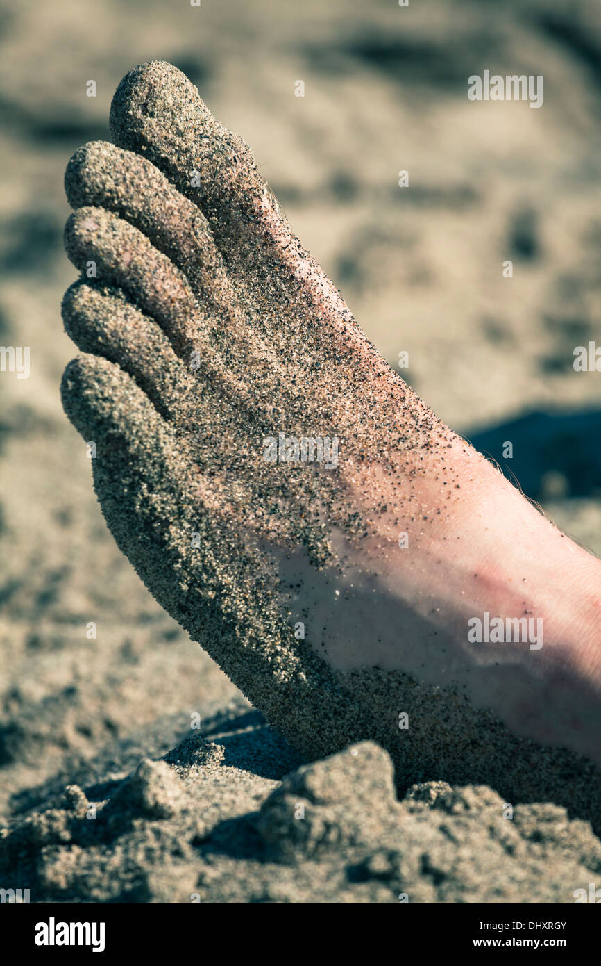 Closeup of male foot in sand. Stock Photo