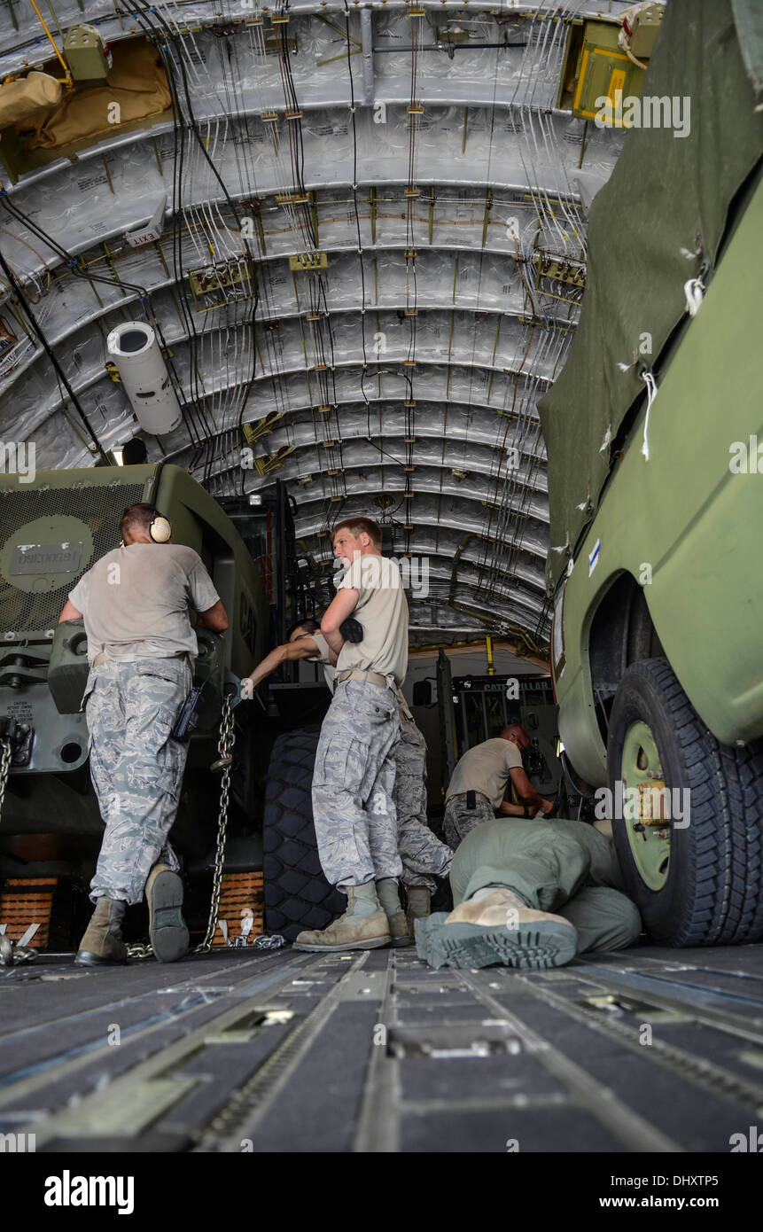Airmen from the 36th Contingency Response Group secure vehicles into a C-17 Globemaster III Nov. 15, 2013, on the Andersen Air Force Base, Guam, flightline before departing to support Operation Damayan in Tacloban, Philippines. Operation Damayan is a U.S. Stock Photo