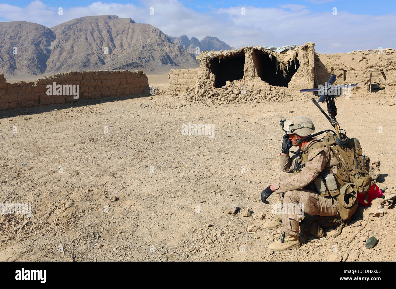 A US Marine with the 1st Battalion, 9th Marine Regiment talks on a radio during a clearing mission in a village November 6, 2013 in Helmand province, Afghanistan. Stock Photo