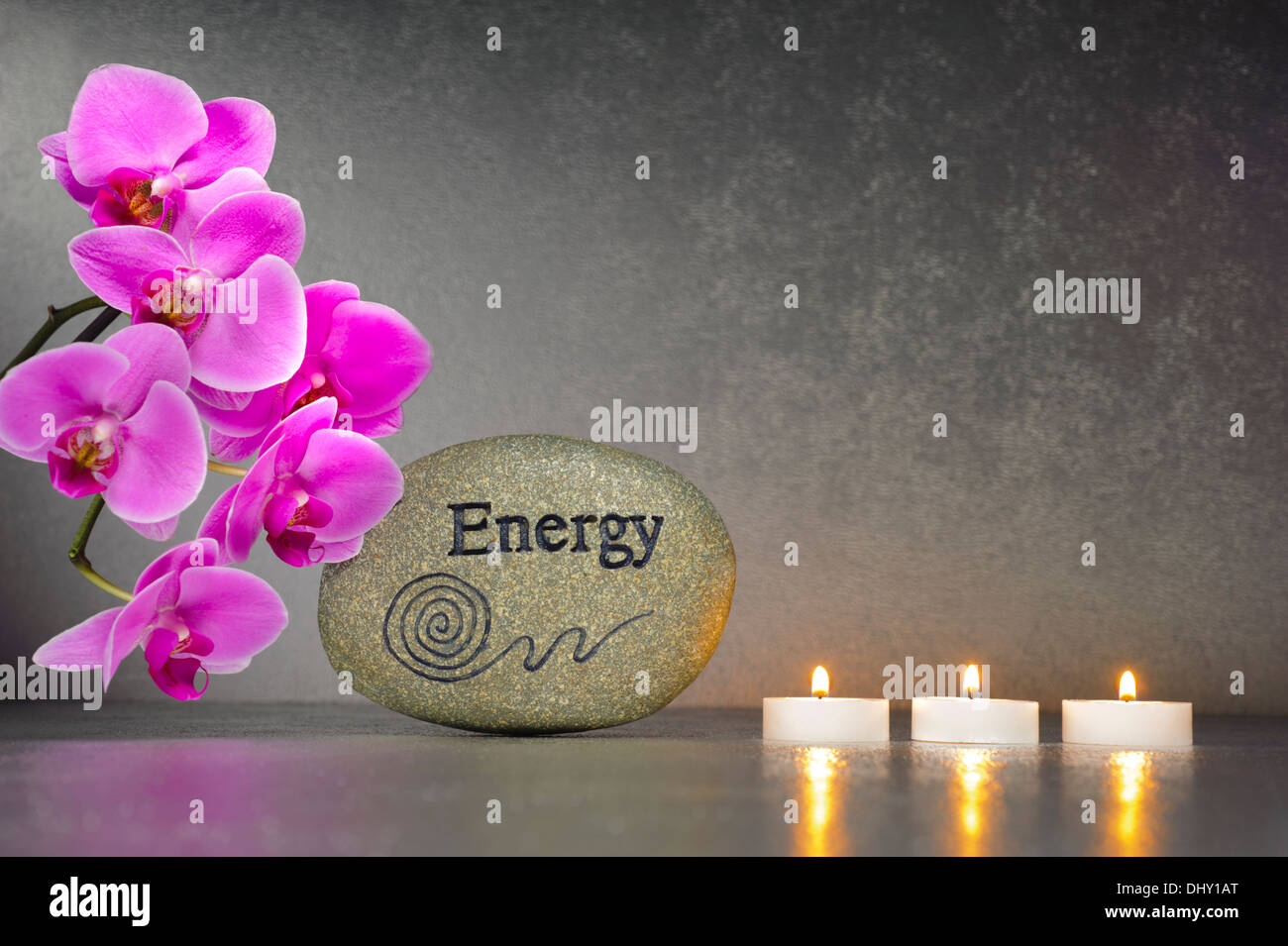 Japanese ZEN garden with stone of energy and candle lights in row with orchid flower Stock Photo