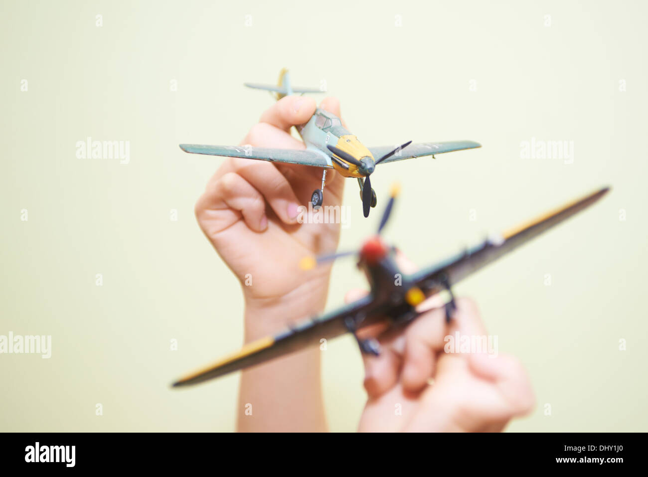 Child blond boy playing - flying with world war II airplanes fighters plastic model kit Stock Photo