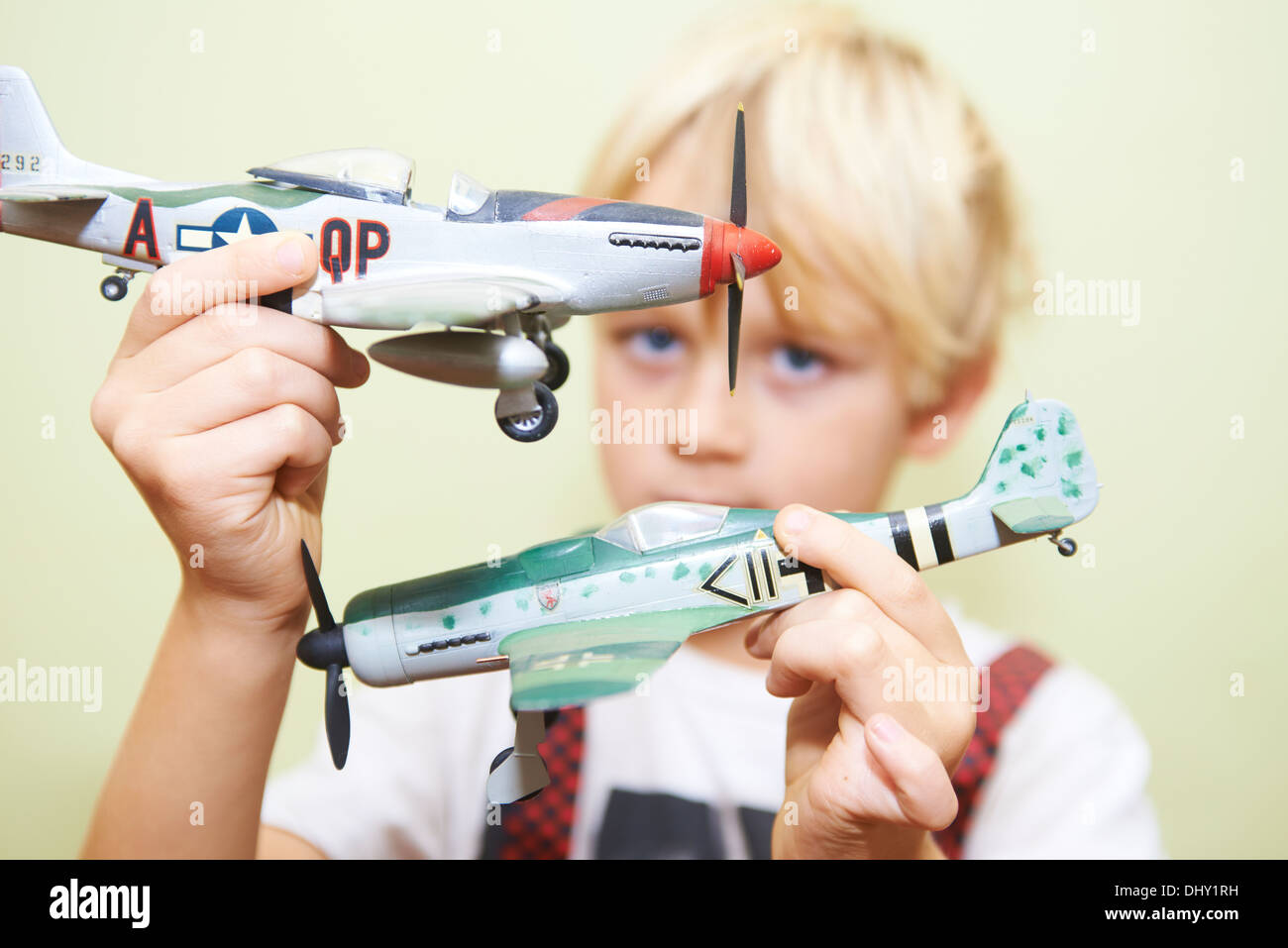 Child blond boy playing - flying with world war II airplanes fighters plastic model kit Stock Photo