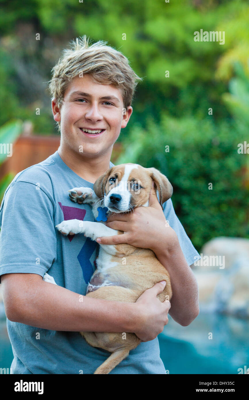 Happy Teenager holding a new Puppy from the dog rescue program in Los Angeles Stock Photo