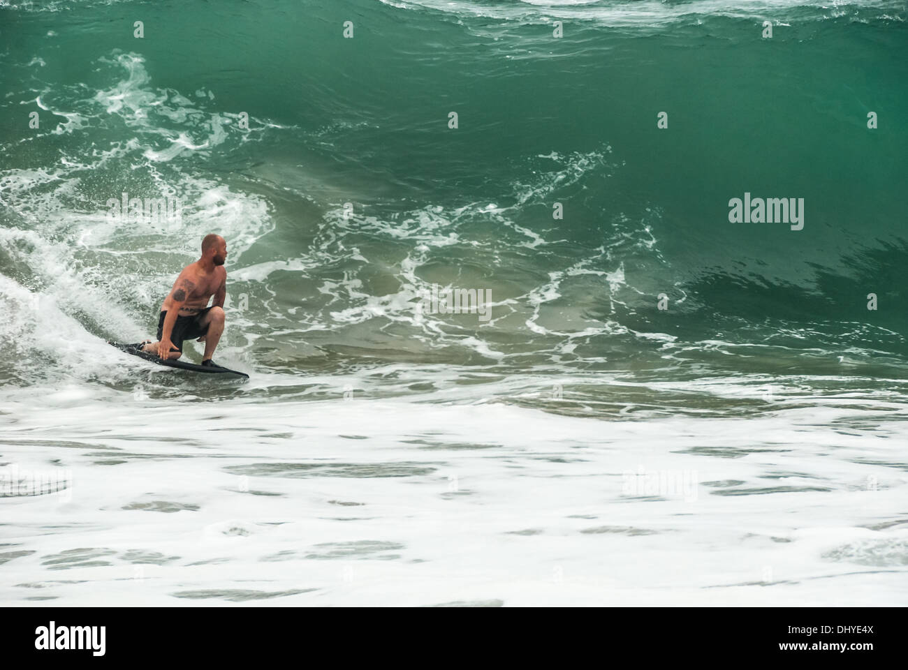 Kneeling bodyboarder navigates a huge, glassy, shorebreak wave at The Wedge in Newport Beach (Orange County), California. (USA) Stock Photo