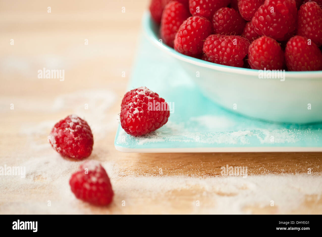 One Raspberry On A Table Raspberries in bowl with some on table and plate sprinkled with sugar ...