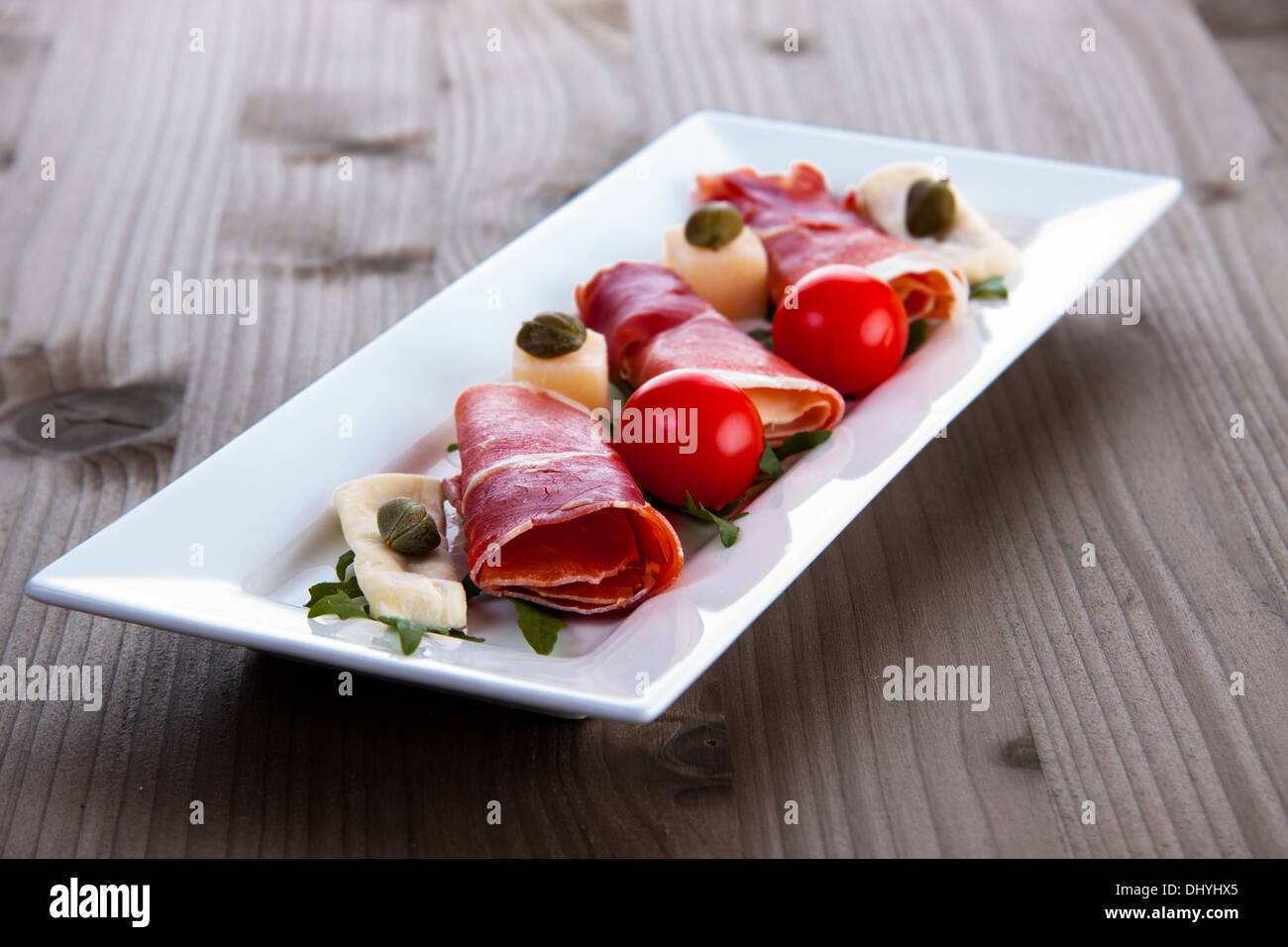 Slices of Delicious Prosciutto with capers, olives and cheese Stock Photo