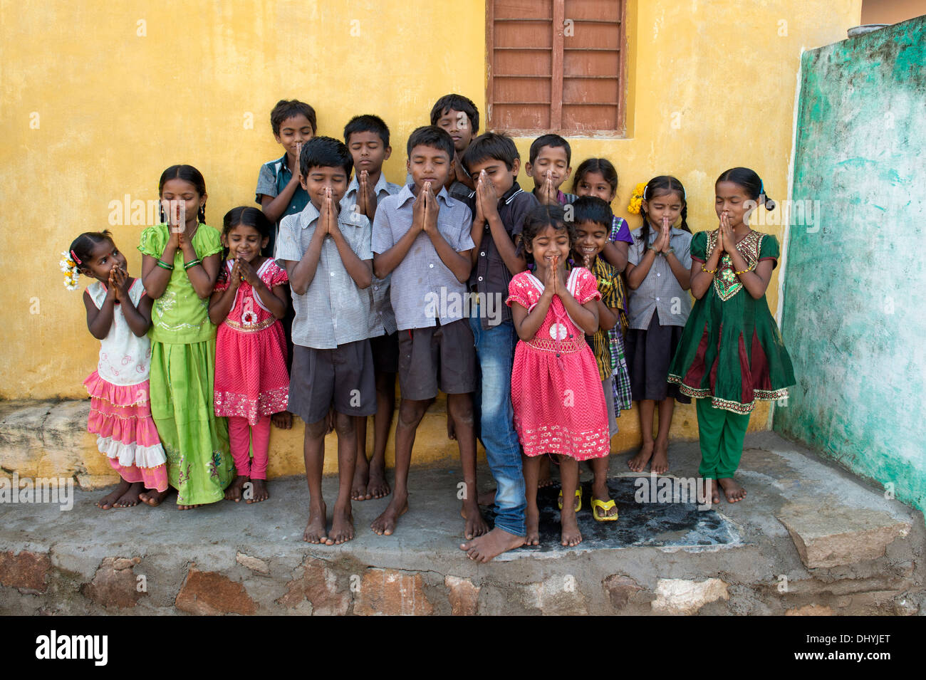 Rural Indian village school children having fun with closed eyes offering namasker. Andhra Pradesh, India Stock Photo