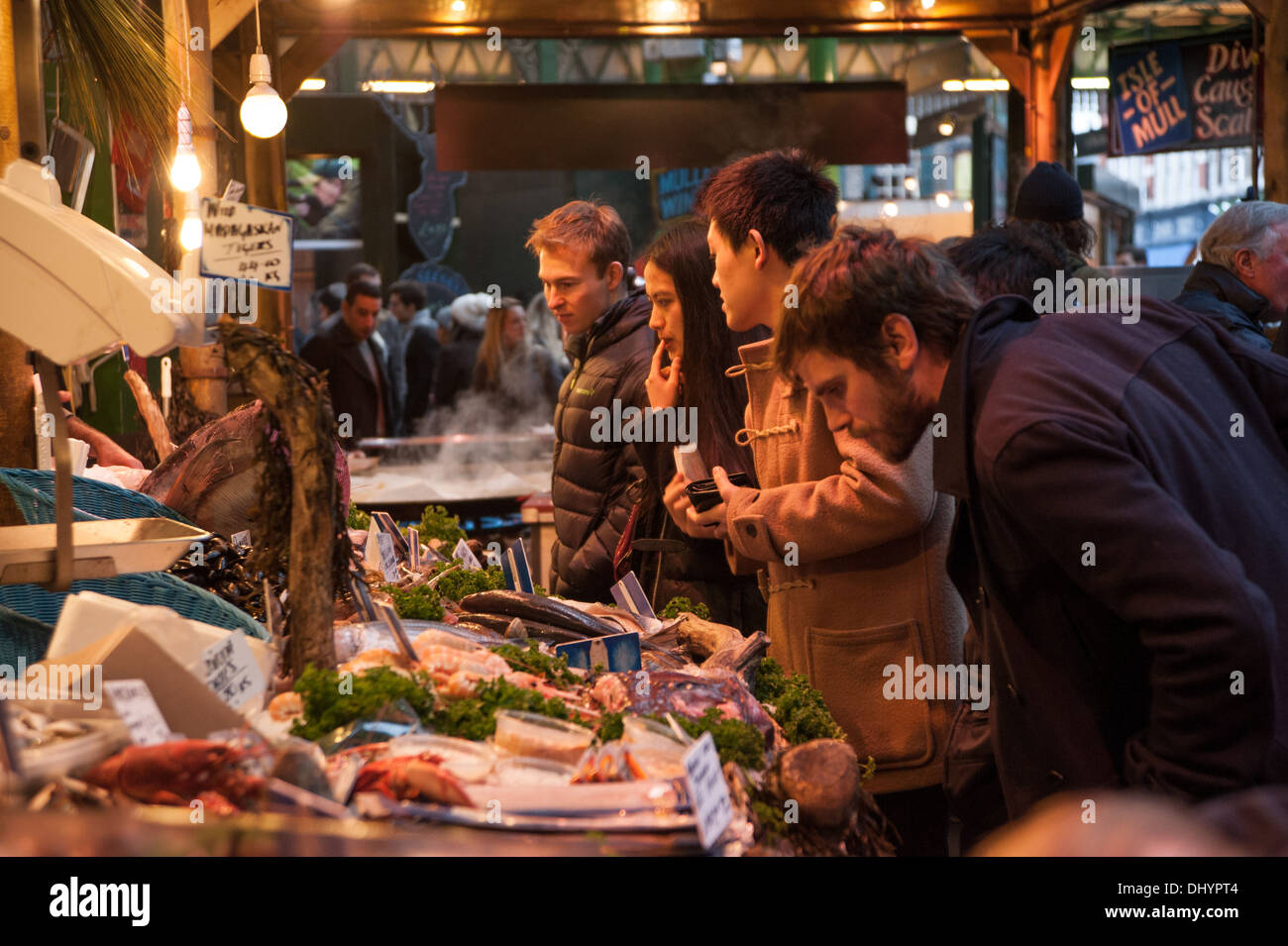 People shopping at busy wet fish stall in Borough Market Southwark London SE1 UK Stock Photo