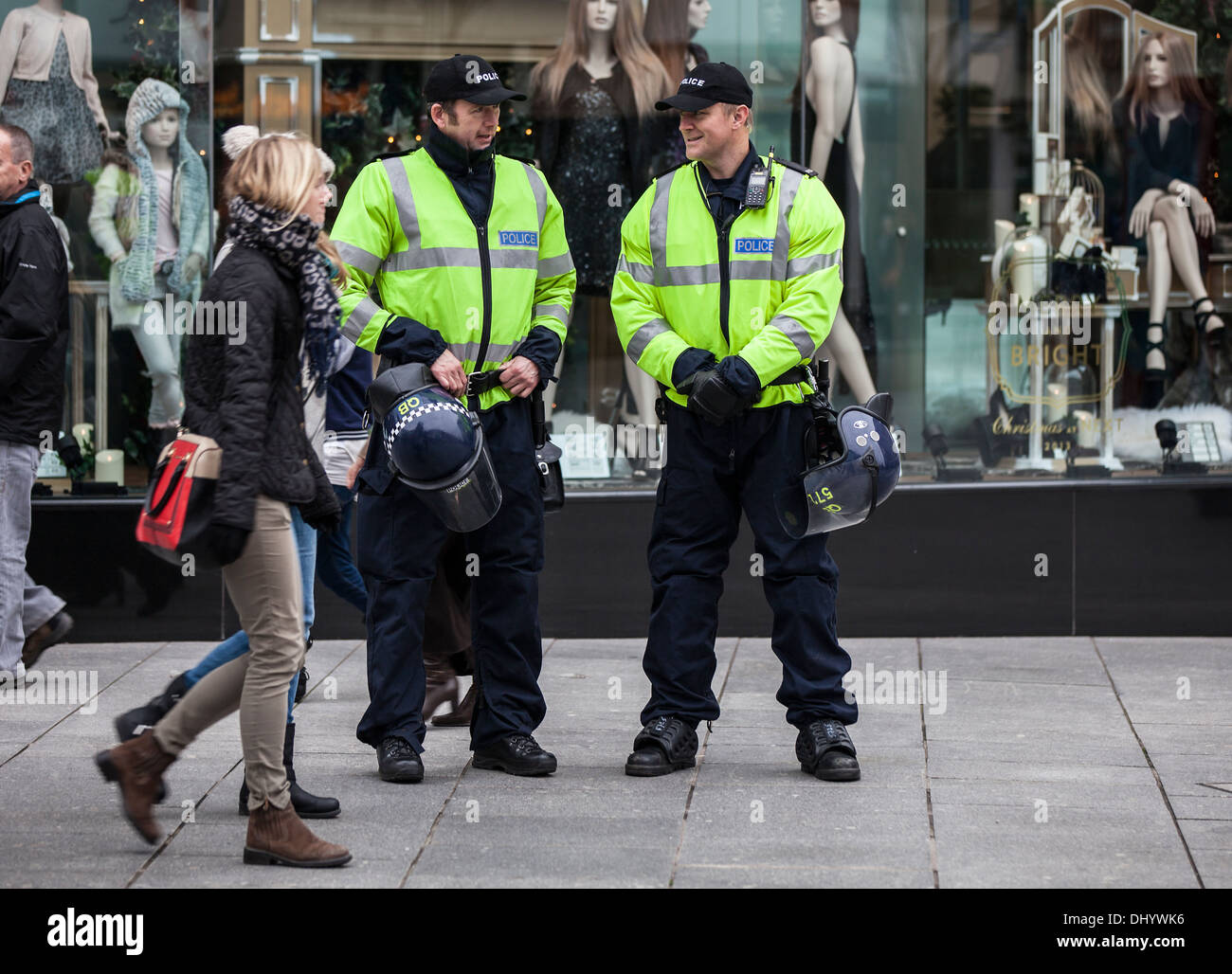 Two British policemen stand holding riot helmets. Stock Photo