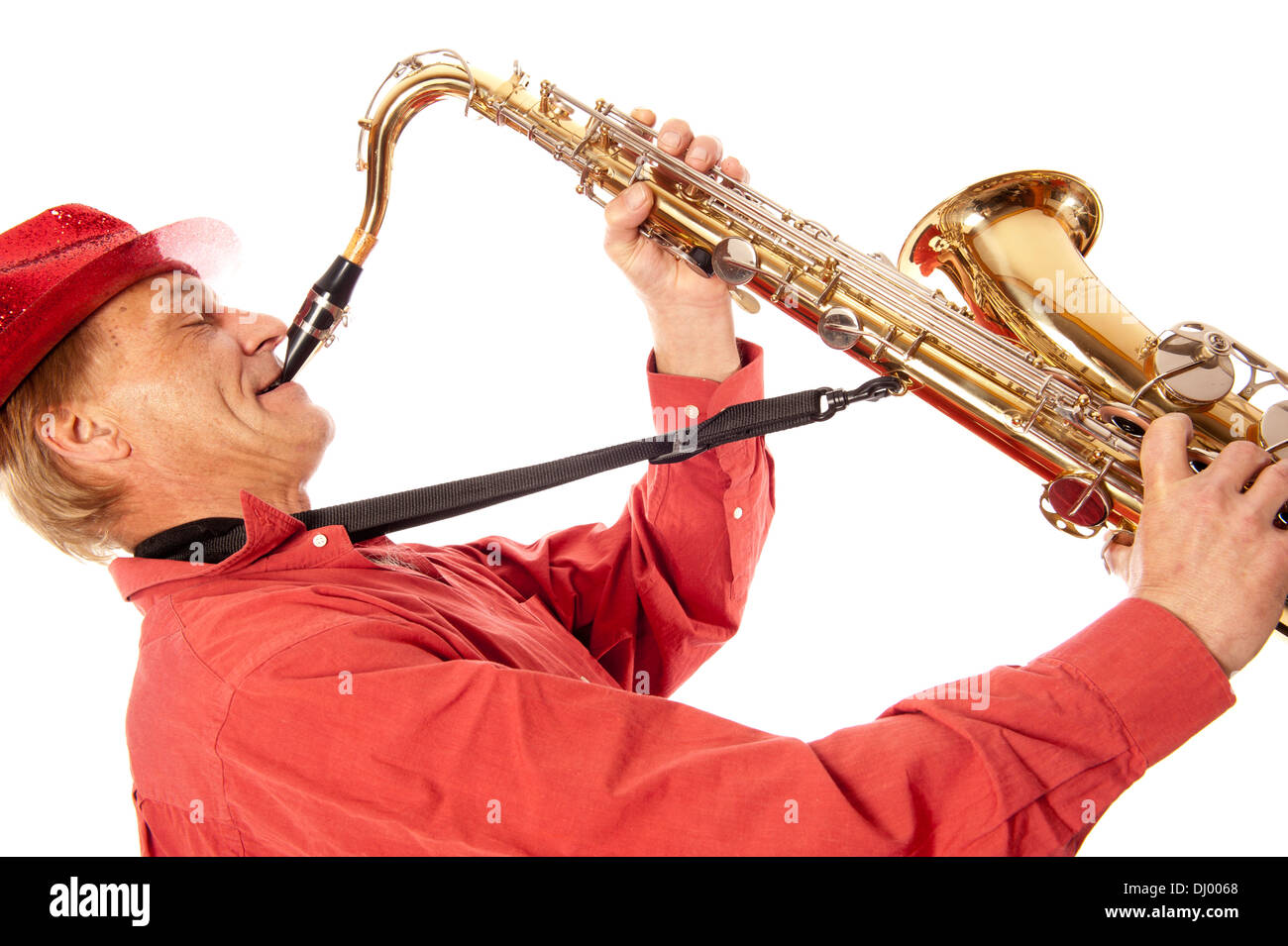 Male performer playing a brass tenor saxophone with silver valves and pearl buttons with expression Stock Photo