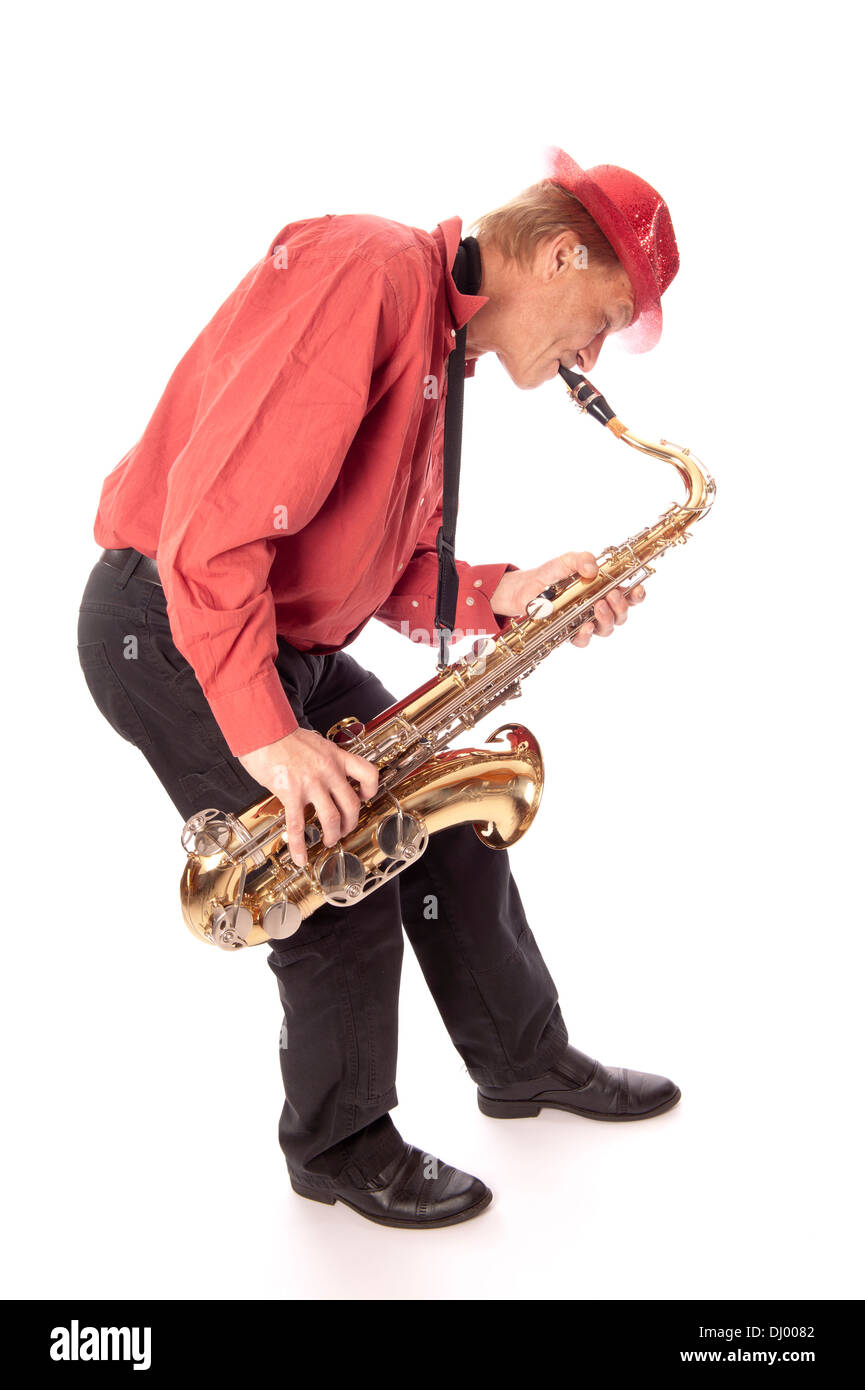 Male performer playing a brass tenor saxophone with silver valves and pearl buttons with bending foreward Stock Photo