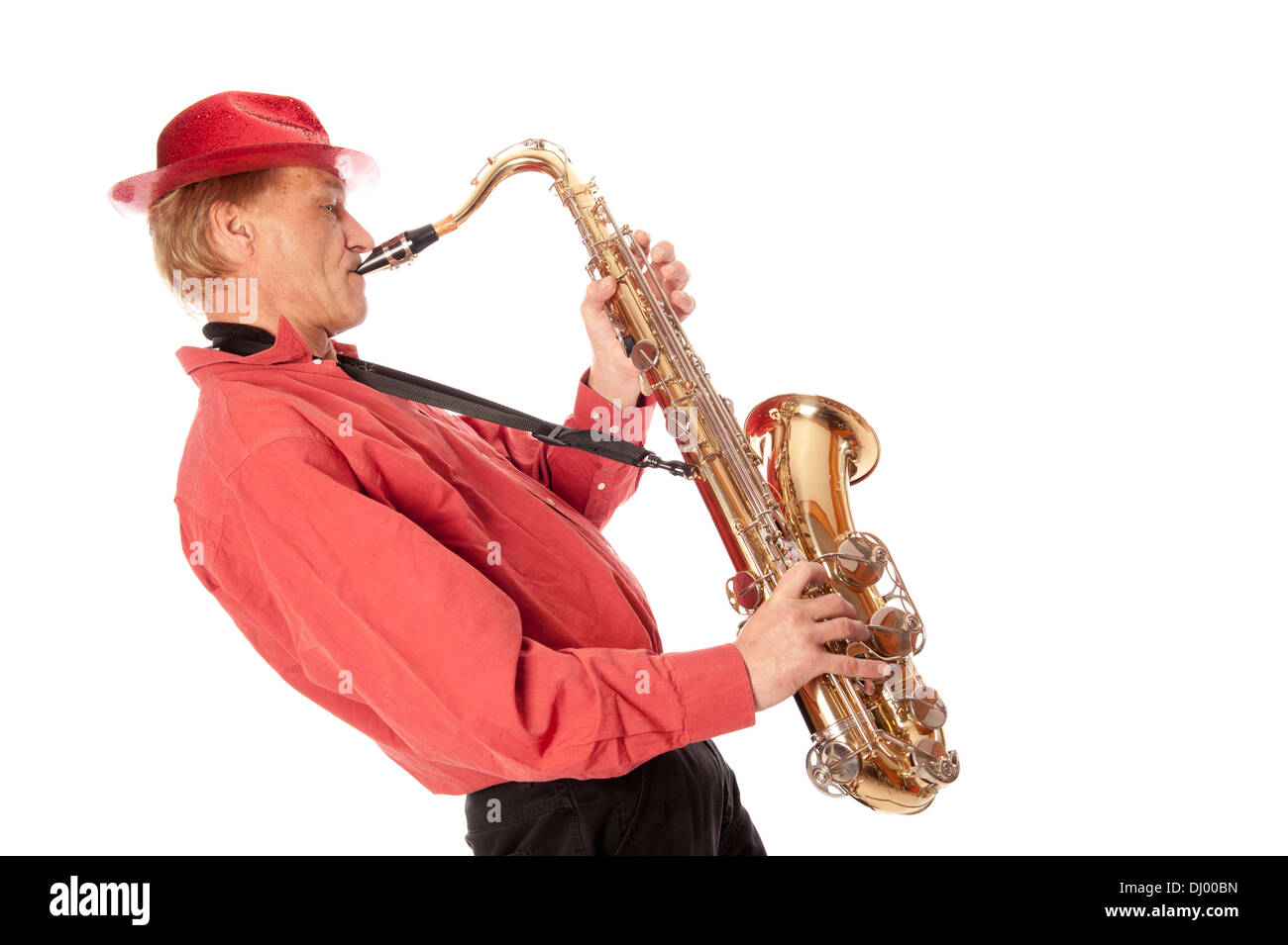 Male performer playing a brass tenor saxophone with silver valves and pearl buttons leaning backwards Stock Photo