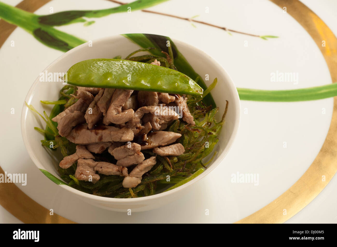 Julienne of crunchy snow peas and liquorice veal strips Stock Photo