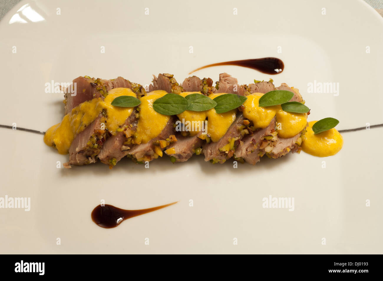 Dried fruit crusted tuna with yellow peppers salty ice cream Stock Photo
