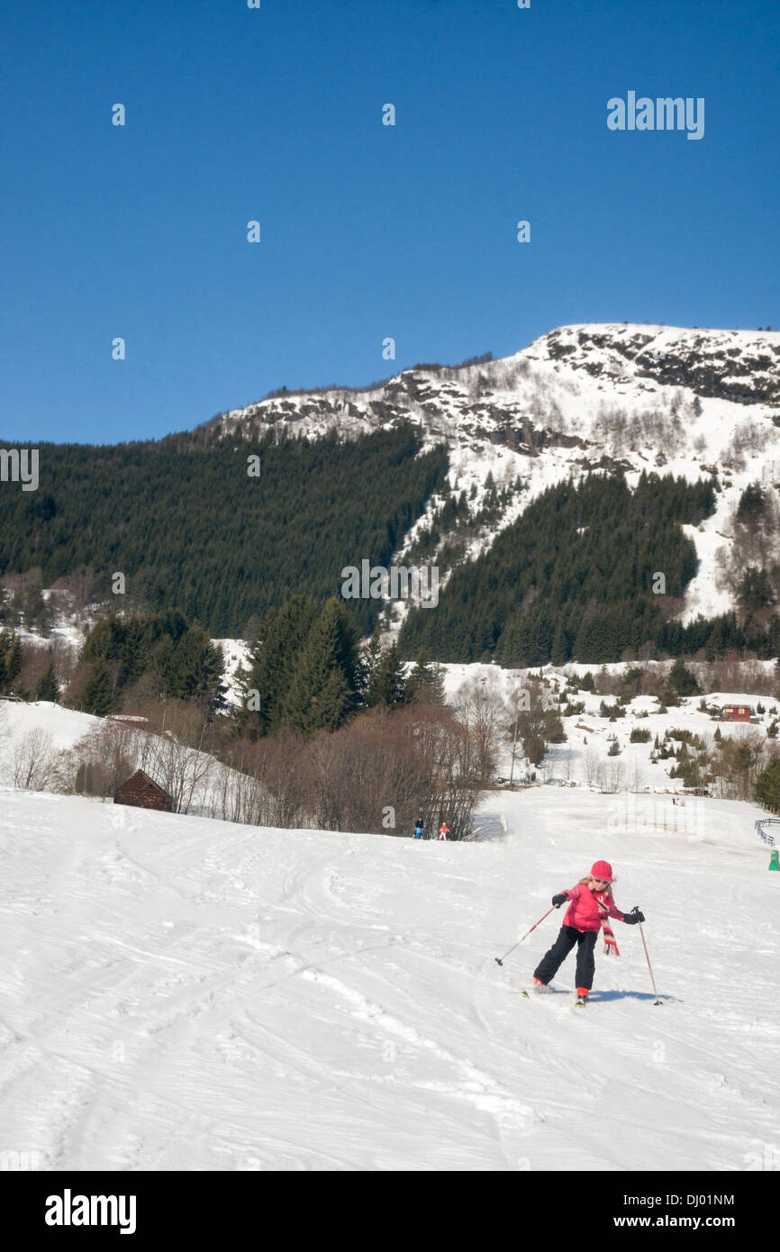 Young girl learning to downhill ski on bunny hill at Sognski center