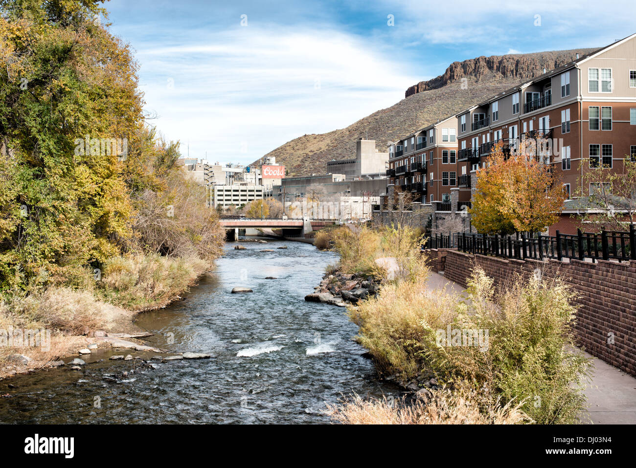 GOLDEN, Colorado - Clear Creek in Golden, Colorado, runs to the Coors Brewery which can be seen in the distance, with part of Table Mountain visible in the background at right. Founded during the Pike's Peak Gold Rush, Golden today is known for its rich heritage, outdoor activities, and being the birthplace of Coors Brewery, embodying a unique blend of history, culture, and natural beauty. Stock Photo