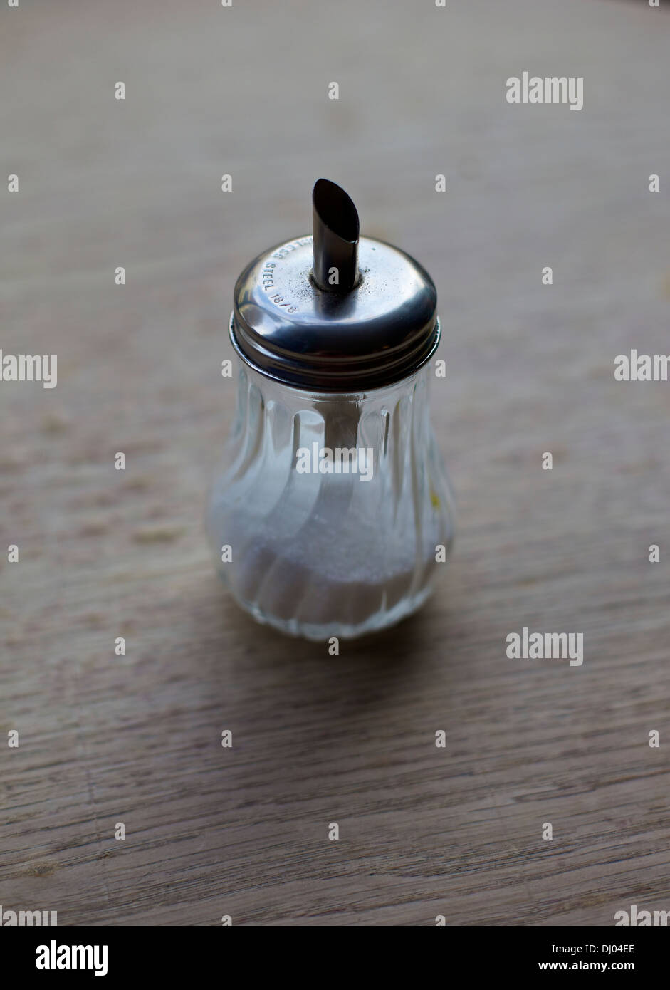 Diner style sugar pourer dispenser on wooden table at posh cafe Stock Photo
