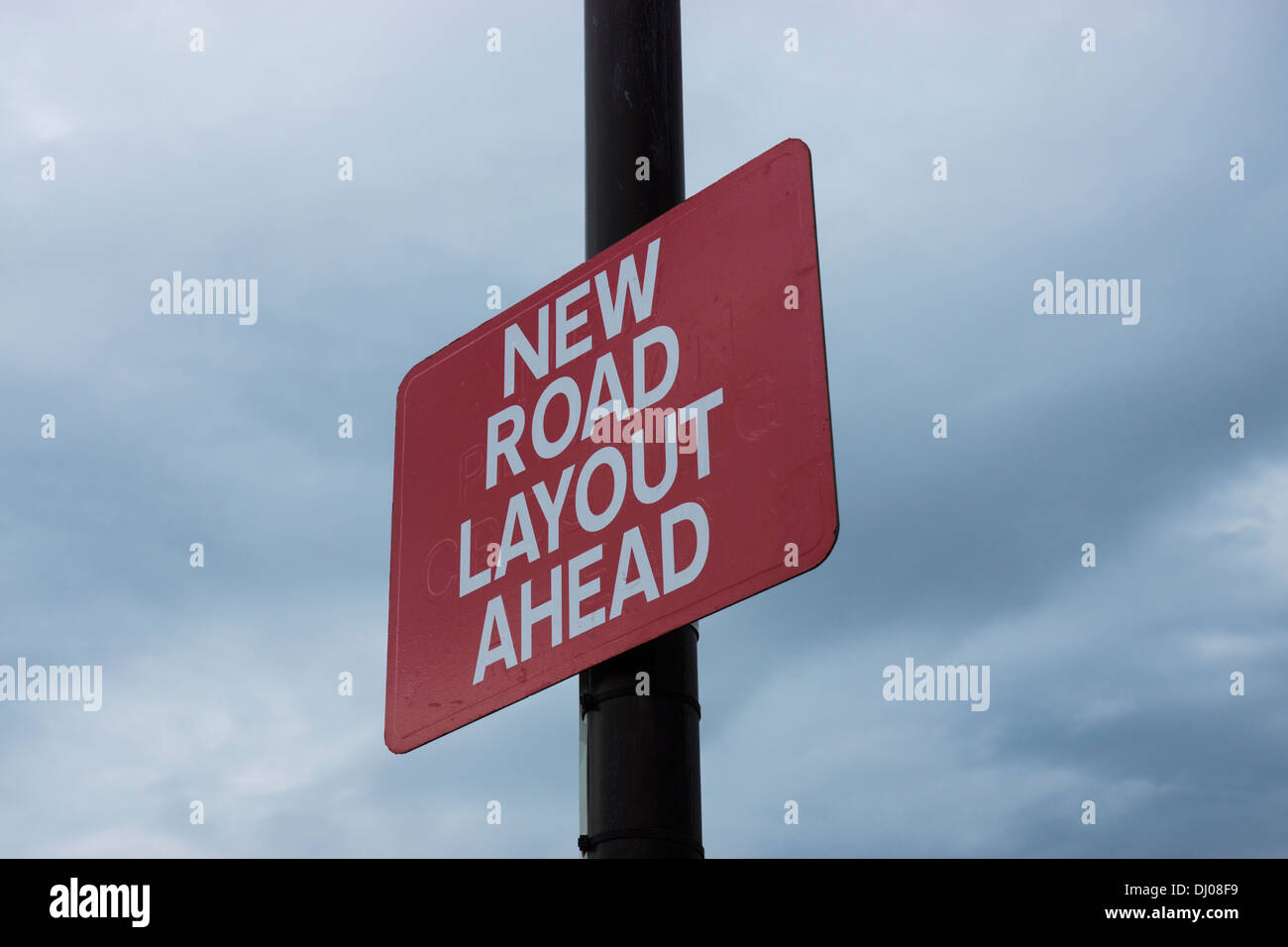 new road layout sign red white letters stormy sky Stock Photo