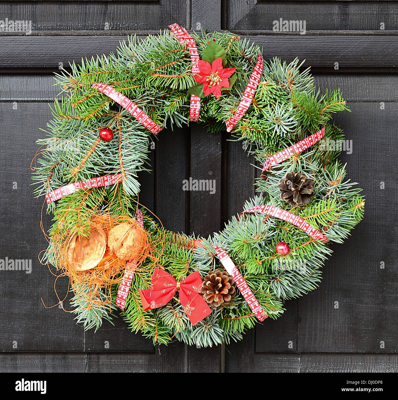 Christmas Wreath With Red Ribbon And Nut Hanging On The Door Stock