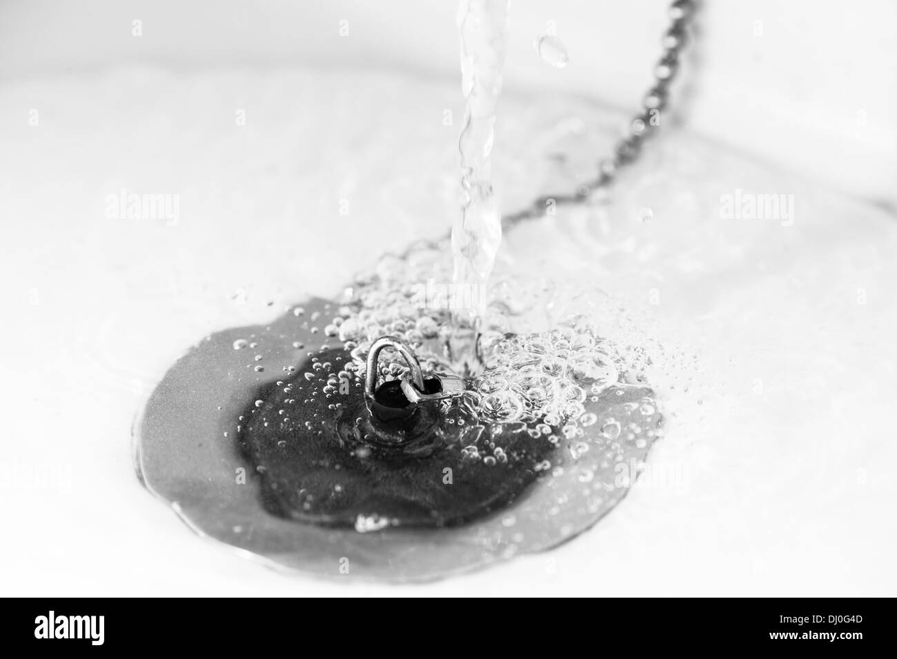 Sink and plug, running water, horizon black and white image Stock Photo