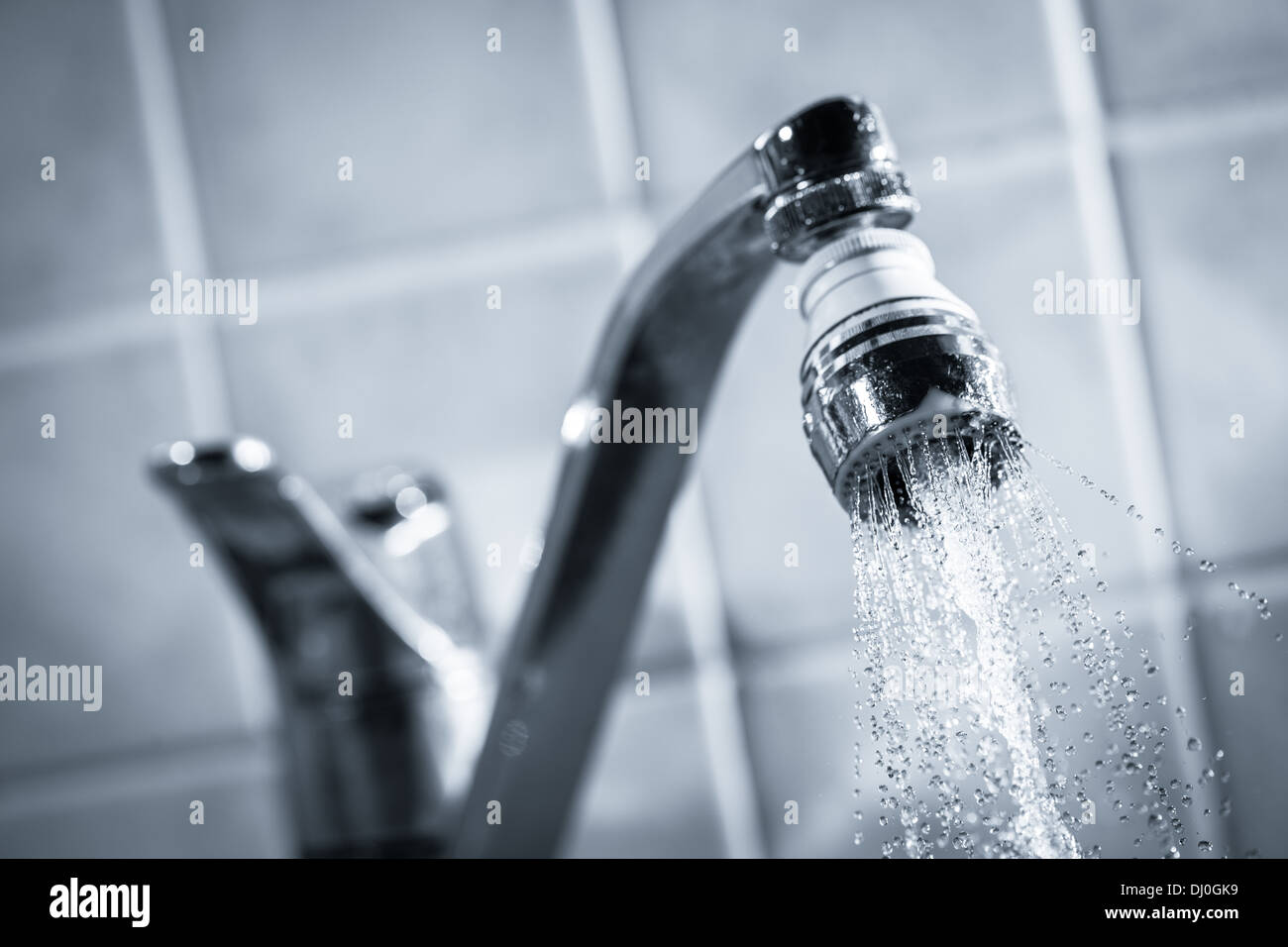 Open faucet, water is running, tinted black and white image Stock Photo