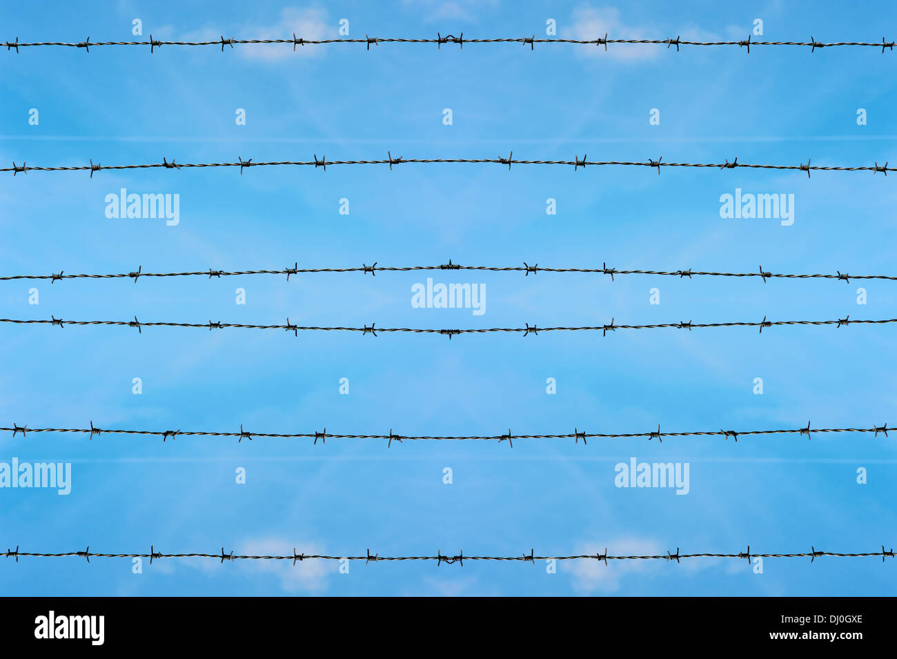 Barbed wire with fence on blue sky background Stock Photo