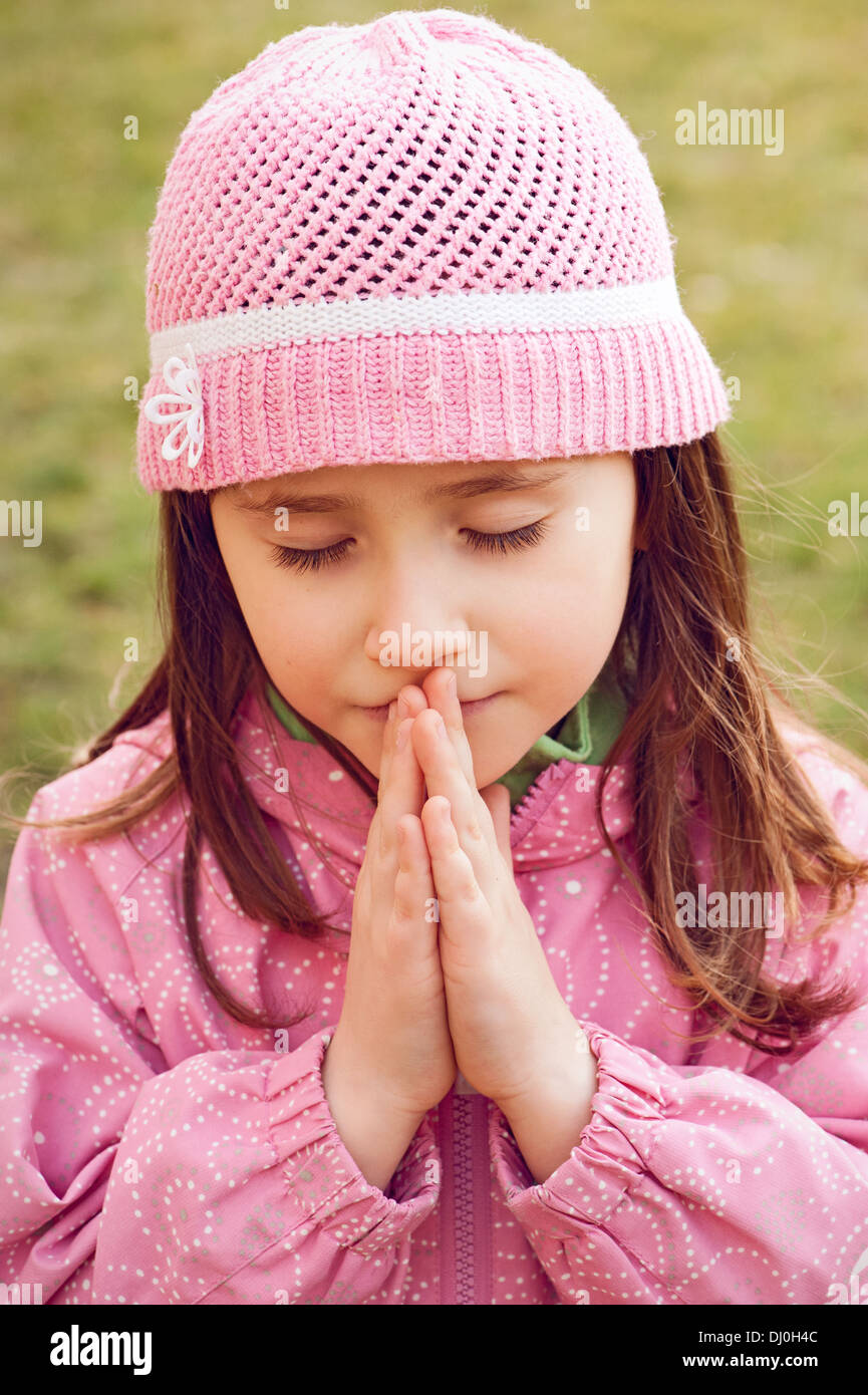 Little girl praying - closeup in the park Stock Photo