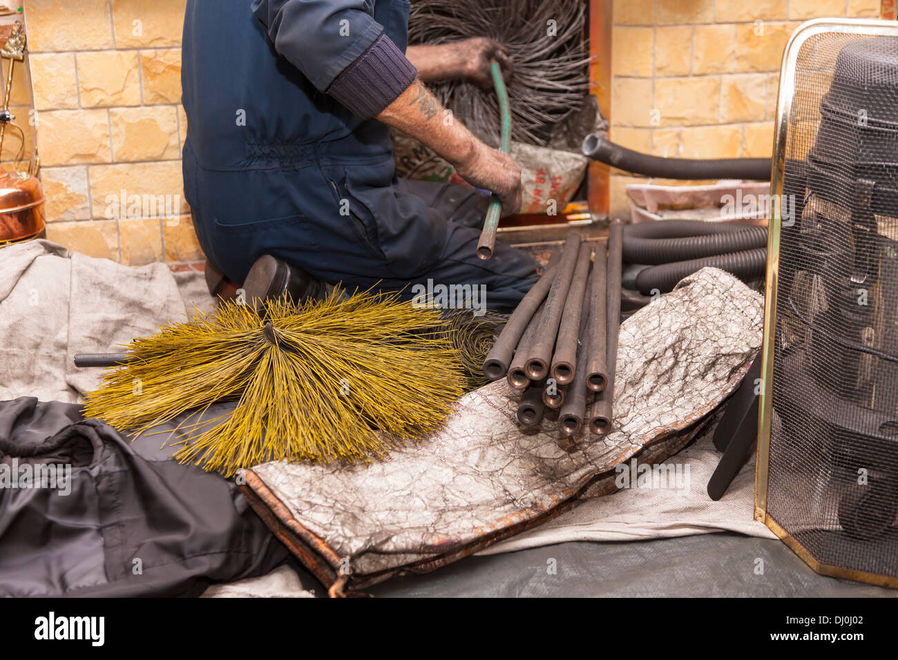 Sweep cleaning a domestic fireplace in a lounge Stock Photo
