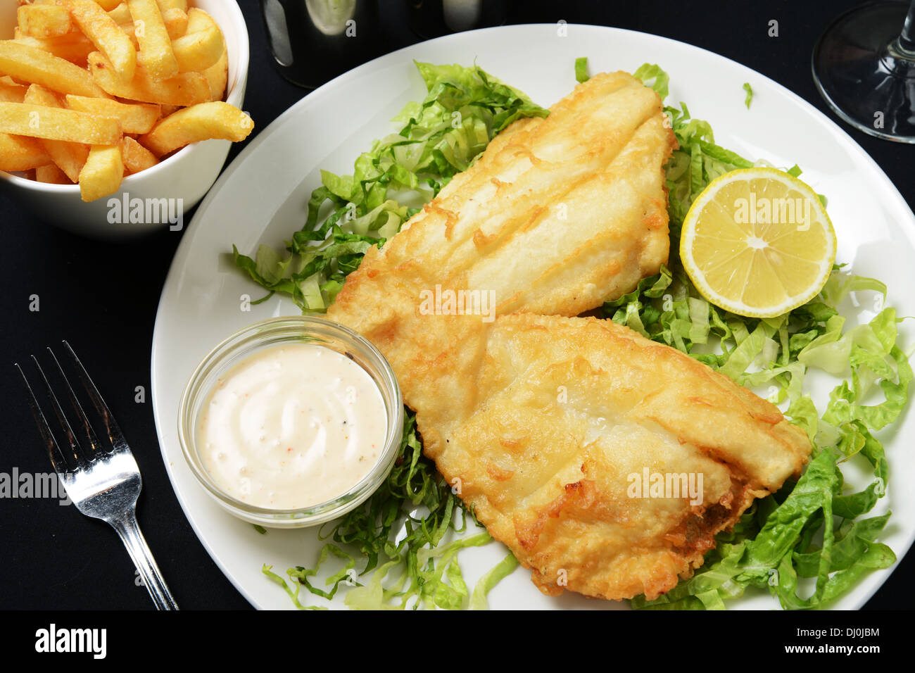 A plate of fried Fish and Chips served on lettuce Stock Photo